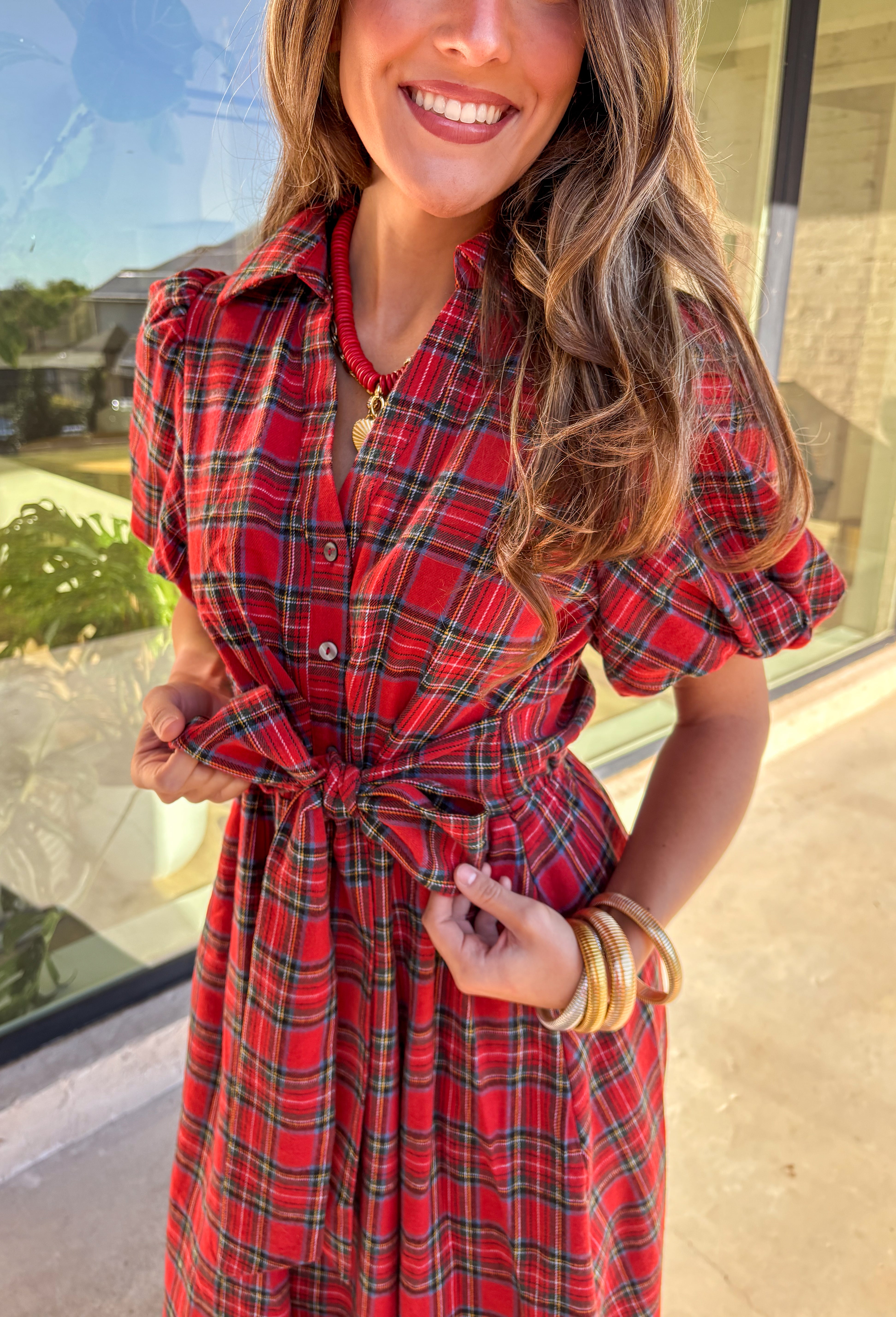 Get ready to celebrate in style with this red plaid midi dress by Entro. Designed with puff sleeves and a button-front closure, it’s both classic and festive. A self-tie waist belt cinches the shape for a flattering fit, while side pockets and a soft lining keep it practical and comfortable. With its cheerful plaid pattern and timeless silhouette, this dress is the perfect choice for holiday gatherings and seasonal events.