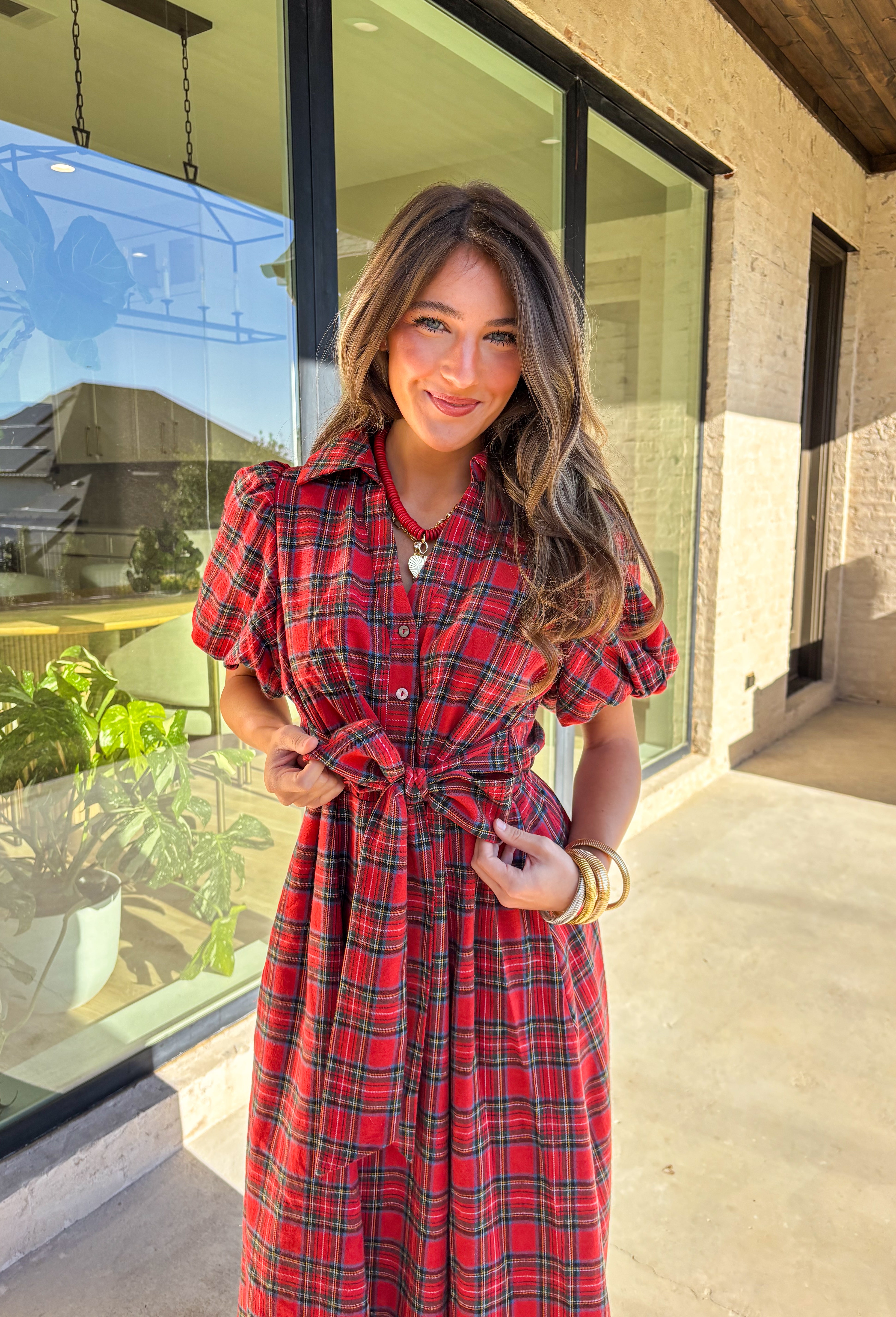 Get ready to celebrate in style with this red plaid midi dress by Entro. Designed with puff sleeves and a button-front closure, it’s both classic and festive. A self-tie waist belt cinches the shape for a flattering fit, while side pockets and a soft lining keep it practical and comfortable. With its cheerful plaid pattern and timeless silhouette, this dress is the perfect choice for holiday gatherings and seasonal events.