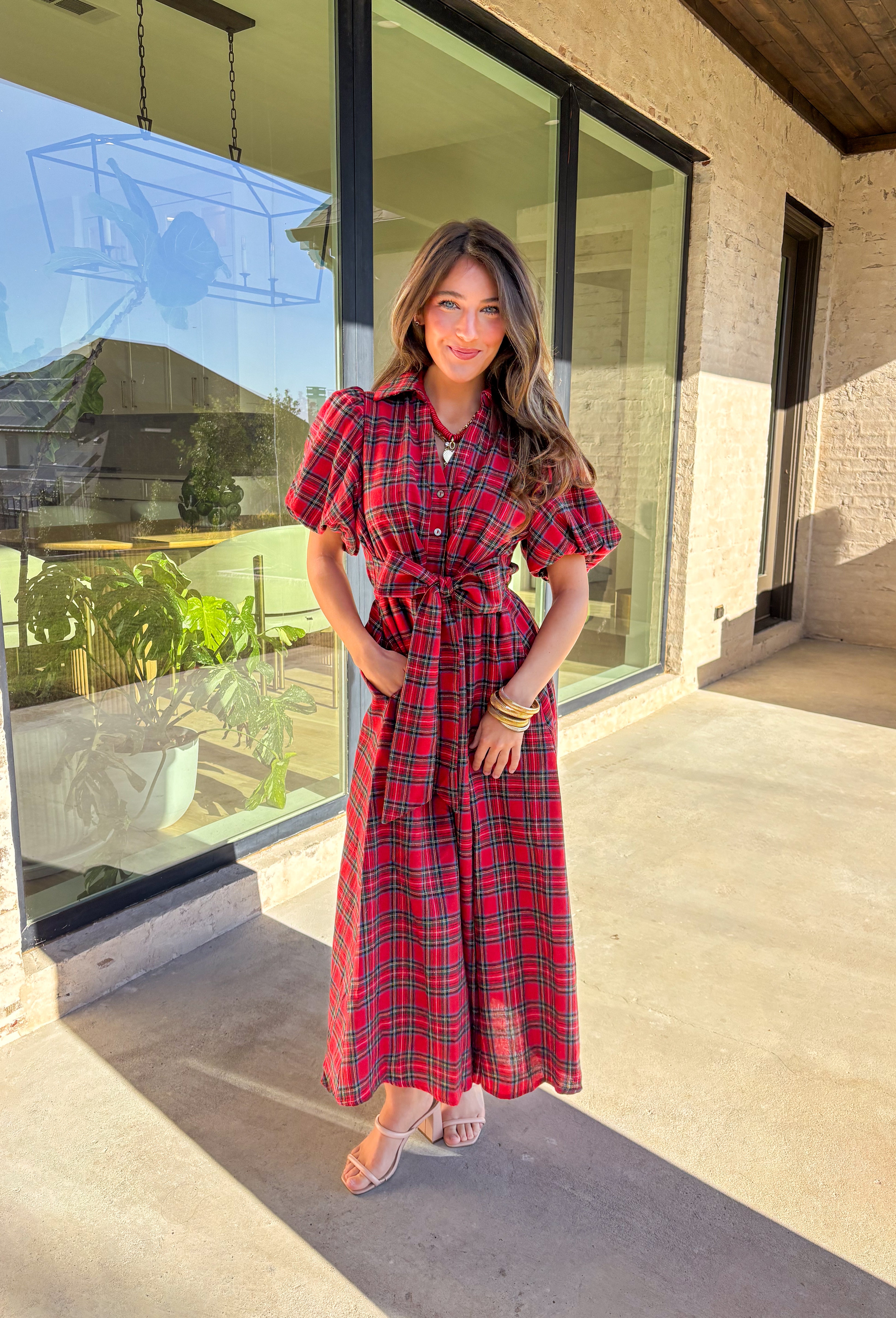 Get ready to celebrate in style with this red plaid midi dress by Entro. Designed with puff sleeves and a button-front closure, it’s both classic and festive. A self-tie waist belt cinches the shape for a flattering fit, while side pockets and a soft lining keep it practical and comfortable. With its cheerful plaid pattern and timeless silhouette, this dress is the perfect choice for holiday gatherings and seasonal events.