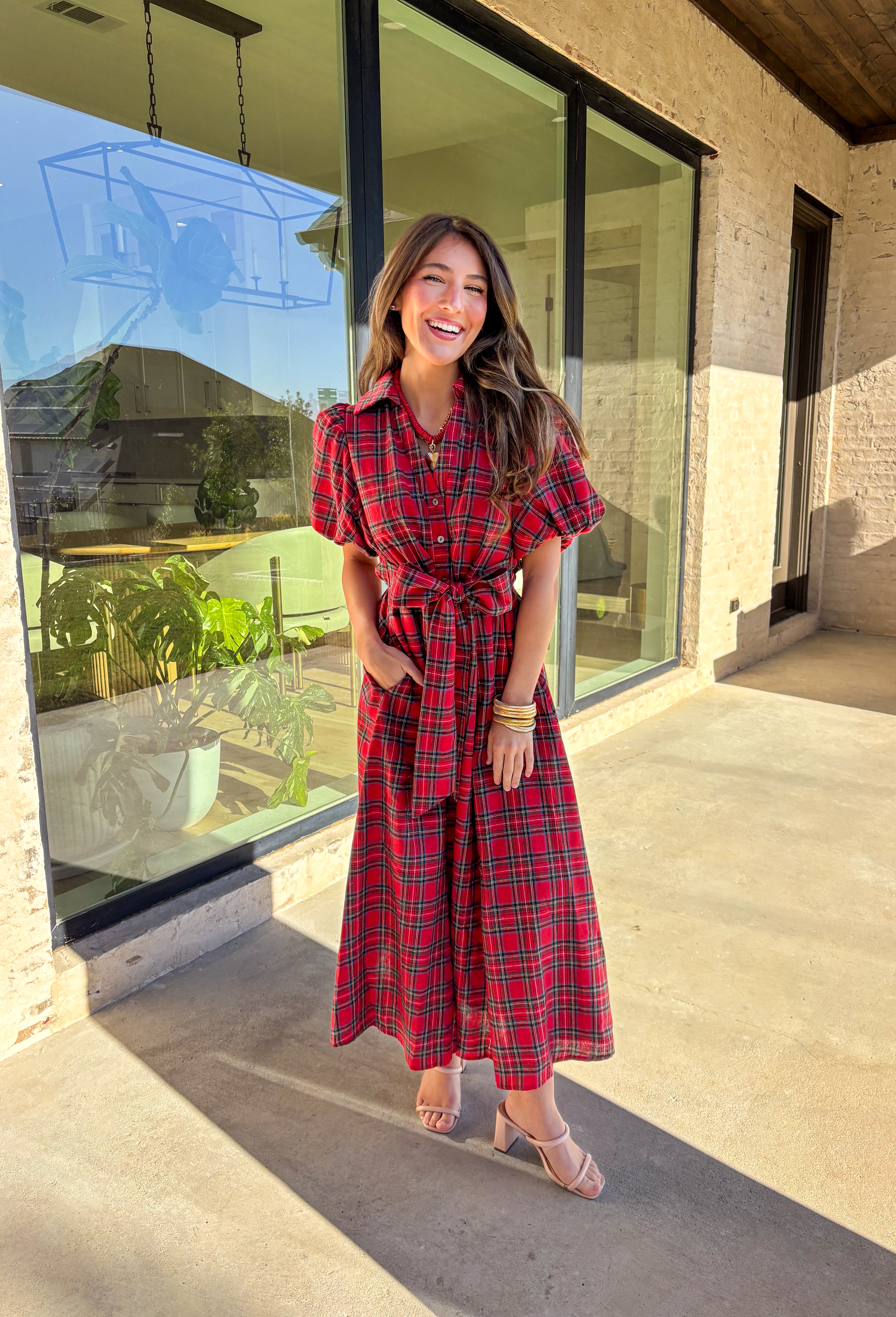 Get ready to celebrate in style with this red plaid midi dress by Entro. Designed with puff sleeves and a button-front closure, it’s both classic and festive. A self-tie waist belt cinches the shape for a flattering fit, while side pockets and a soft lining keep it practical and comfortable. With its cheerful plaid pattern and timeless silhouette, this dress is the perfect choice for holiday gatherings and seasonal events.