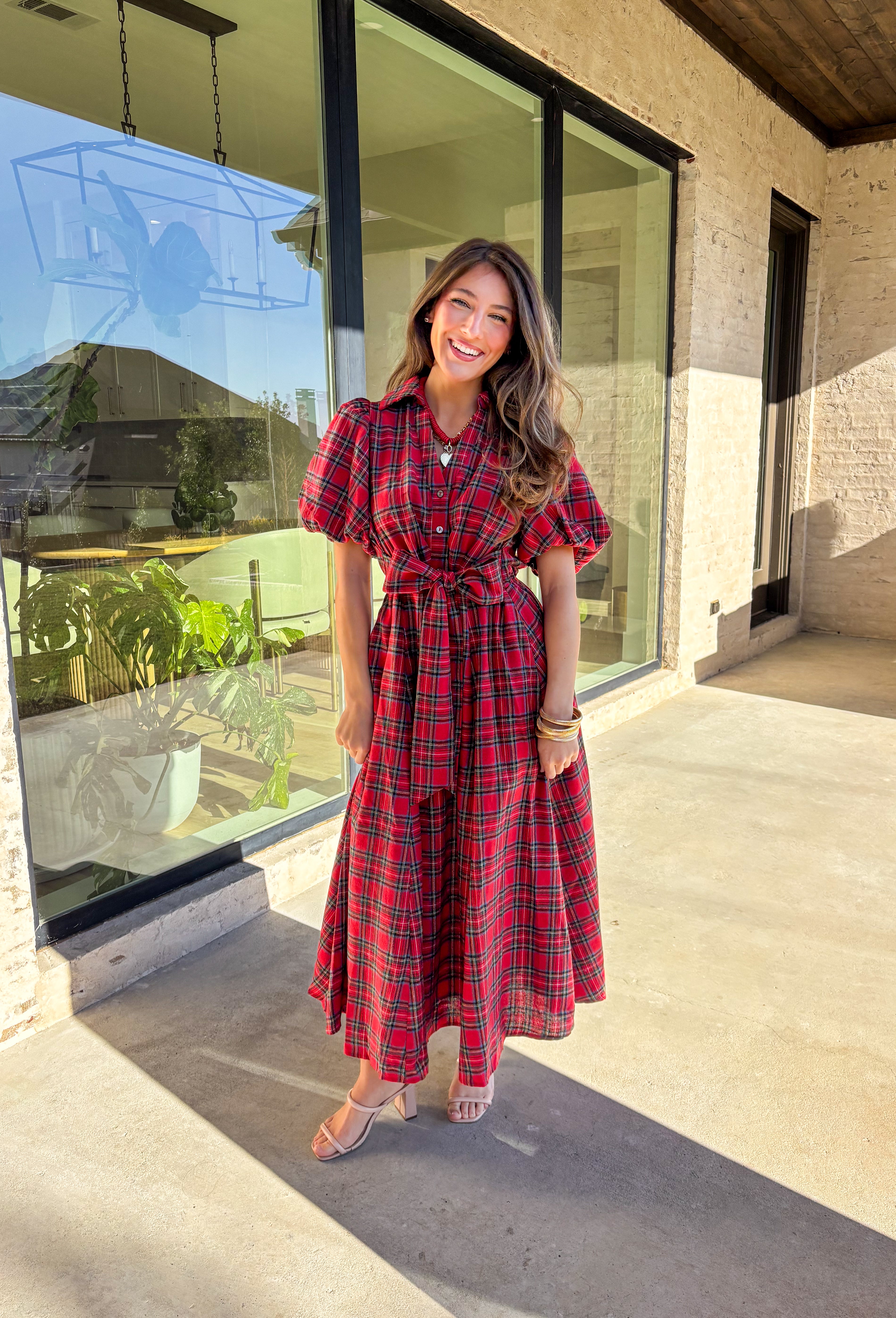 Get ready to celebrate in style with this red plaid midi dress by Entro. Designed with puff sleeves and a button-front closure, it’s both classic and festive. A self-tie waist belt cinches the shape for a flattering fit, while side pockets and a soft lining keep it practical and comfortable. With its cheerful plaid pattern and timeless silhouette, this dress is the perfect choice for holiday gatherings and seasonal events.