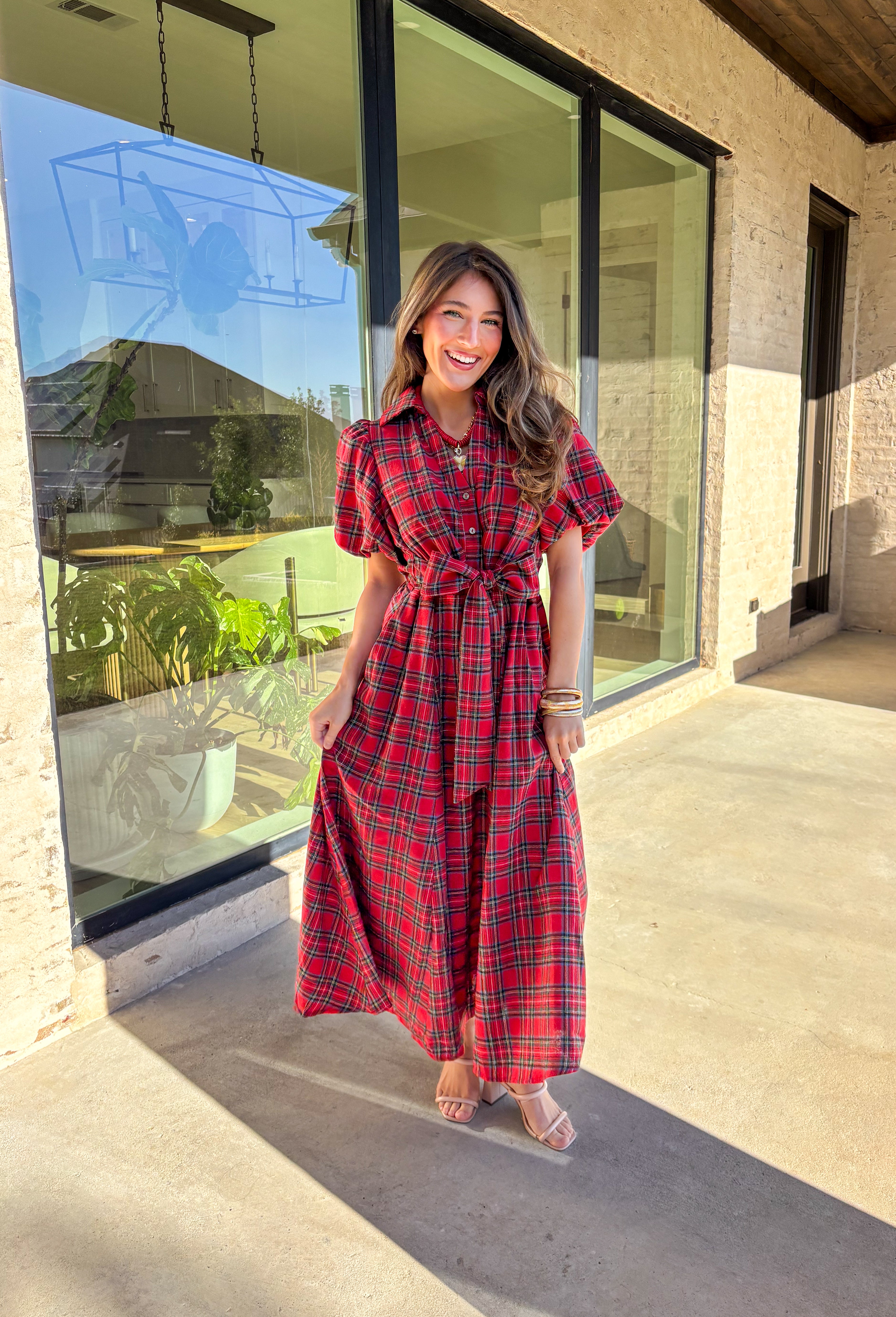 Get ready to celebrate in style with this red plaid midi dress by Entro. Designed with puff sleeves and a button-front closure, it’s both classic and festive. A self-tie waist belt cinches the shape for a flattering fit, while side pockets and a soft lining keep it practical and comfortable. With its cheerful plaid pattern and timeless silhouette, this dress is the perfect choice for holiday gatherings and seasonal events.