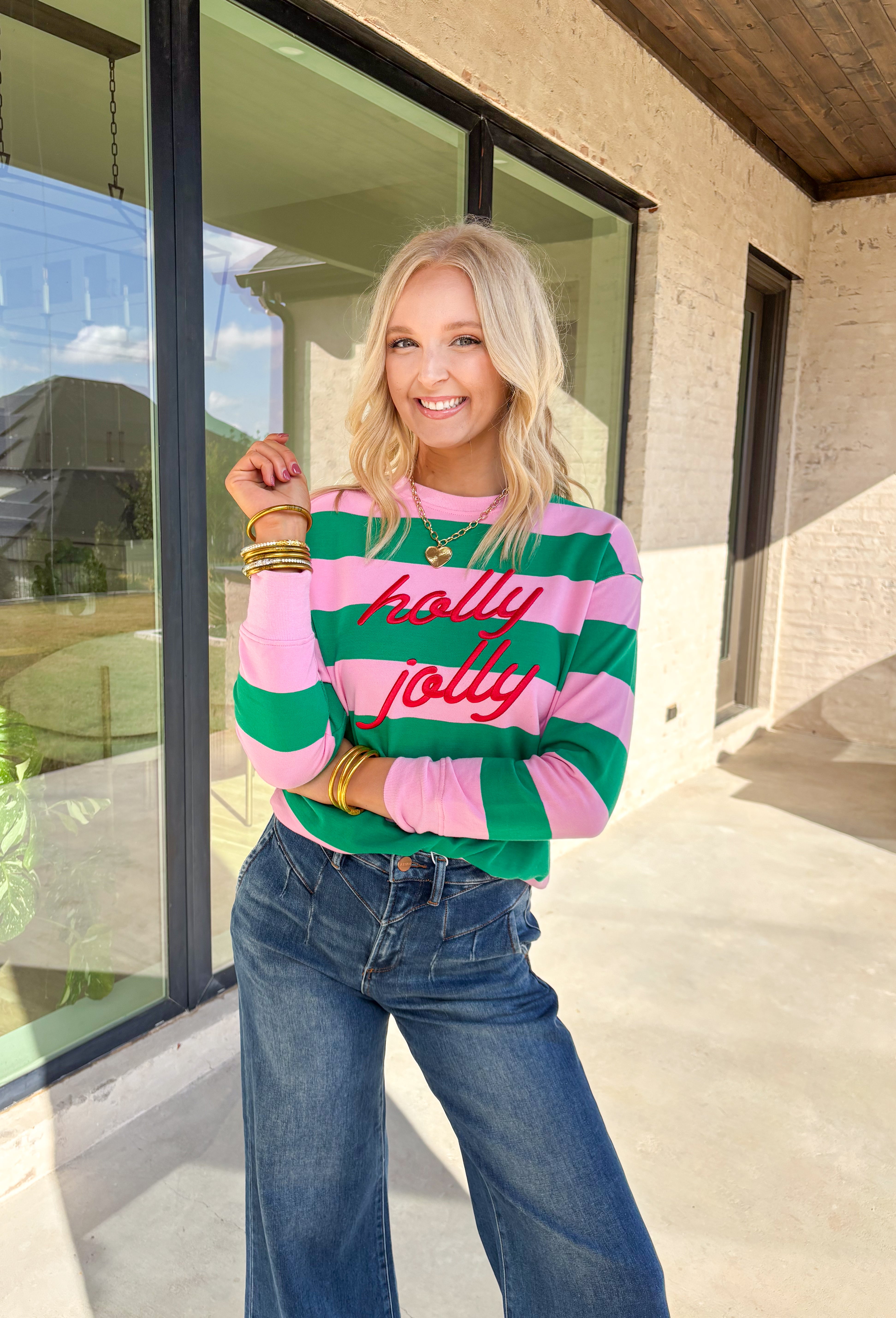 Bring a little merry to your winter wardrobe with this playful “Holly Jolly” pullover by Shiraleah! Designed in pink and green stripes with festive red embroidery across the front, this cozy sweatshirt is equal parts cute and comfortable. Whether you’re wrapping gifts, sipping cocoa, or heading to a holiday get-together, this cheerful piece keeps the spirit bright all season long.