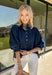 A classic denim top is a wardrobe staple, and this beautifully detailed top from Entro is one you'll wear on repeat. Designed in a rich dark wash denim, this timeless piece features a gold button-front design that makes it easy to style for any occasion. The ¾ puff sleeves add a feminine touch, while the self-tie cuffs create a charming finishing detail.