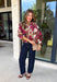 Deep merlot brings a rich seasonal feel to this floral top from Entro. The neutral floral print softens the bold background with warm, easy-to-style shades that fit beautifully into a late-fall wardrobe. A high neckline and button-front closure give the top a classic look, while contrast trim adds another eye-catching detail. The ¾ puff sleeves are finished with buttoned cuffs, and gathering along the back yoke adds subtle shape and movement. 
