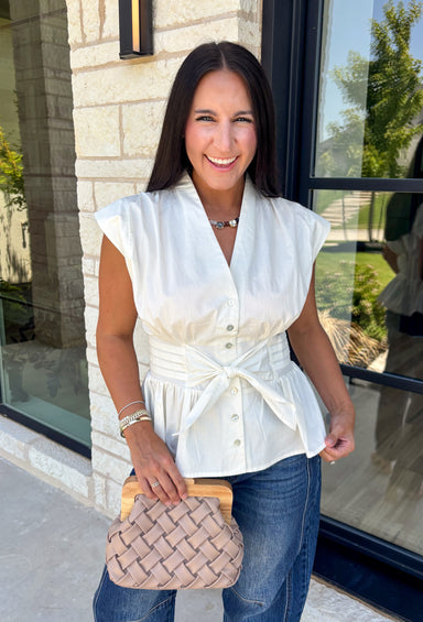 A timeless neutral is always in style, and this cream blouse is one you'll wear on repeat all season long! Designed with a flattering v-neckline and an adjustable self-tie waist, this feminine top creates a beautifully tailored silhouette with effortless comfort. The button front adds a polished touch, while the smocked elastic back offers a flexible, flattering fit. 