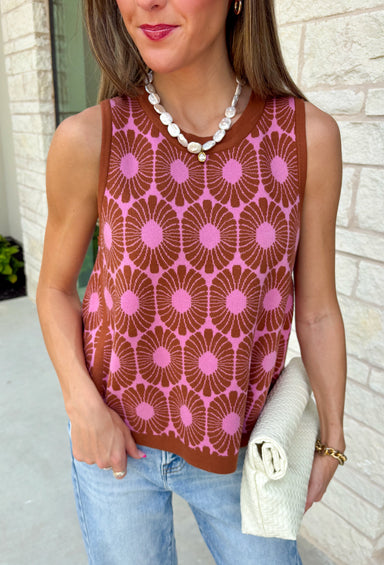 Bold florals and cozy knits make the perfect combination for fall! This sleeveless sweater features a beautiful pink and rust floral pattern that brings a feminine touch to your seasonal wardrobe. Finished with contrast ribbed trim, this lightweight knit is perfect for layering under your favorite blazer, or denim jacket as the weather cools. Whether you're heading to the office, brunch with friends, or a weekend outing, this versatile sweater tank makes transitioning into autumn effortless and stylish.