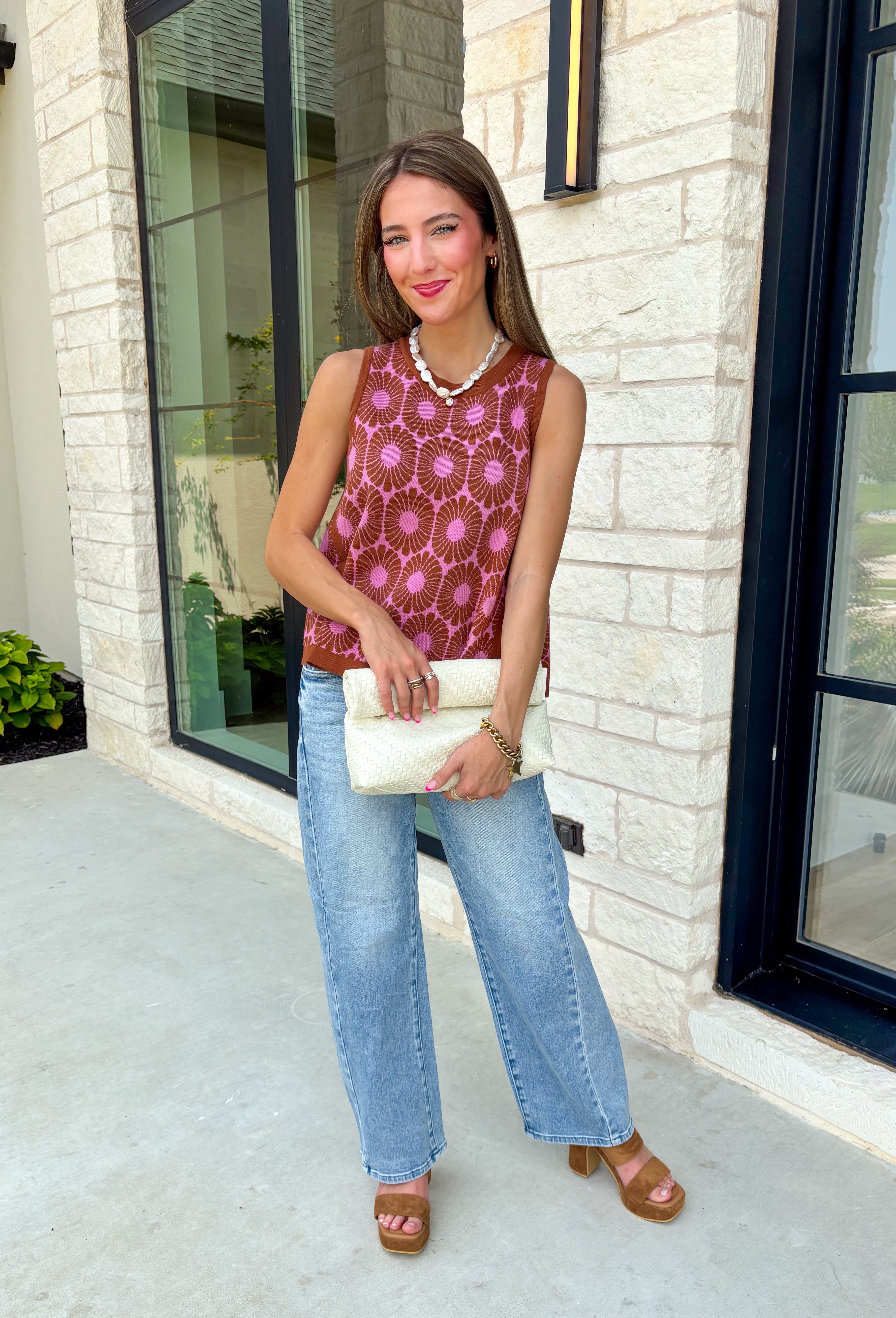 Bold florals and cozy knits make the perfect combination for fall! This sleeveless sweater features a beautiful pink and rust floral pattern that brings a feminine touch to your seasonal wardrobe. Finished with contrast ribbed trim, this lightweight knit is perfect for layering under your favorite blazer, or denim jacket as the weather cools. Whether you're heading to the office, brunch with friends, or a weekend outing, this versatile sweater tank makes transitioning into autumn effortless and stylish.
