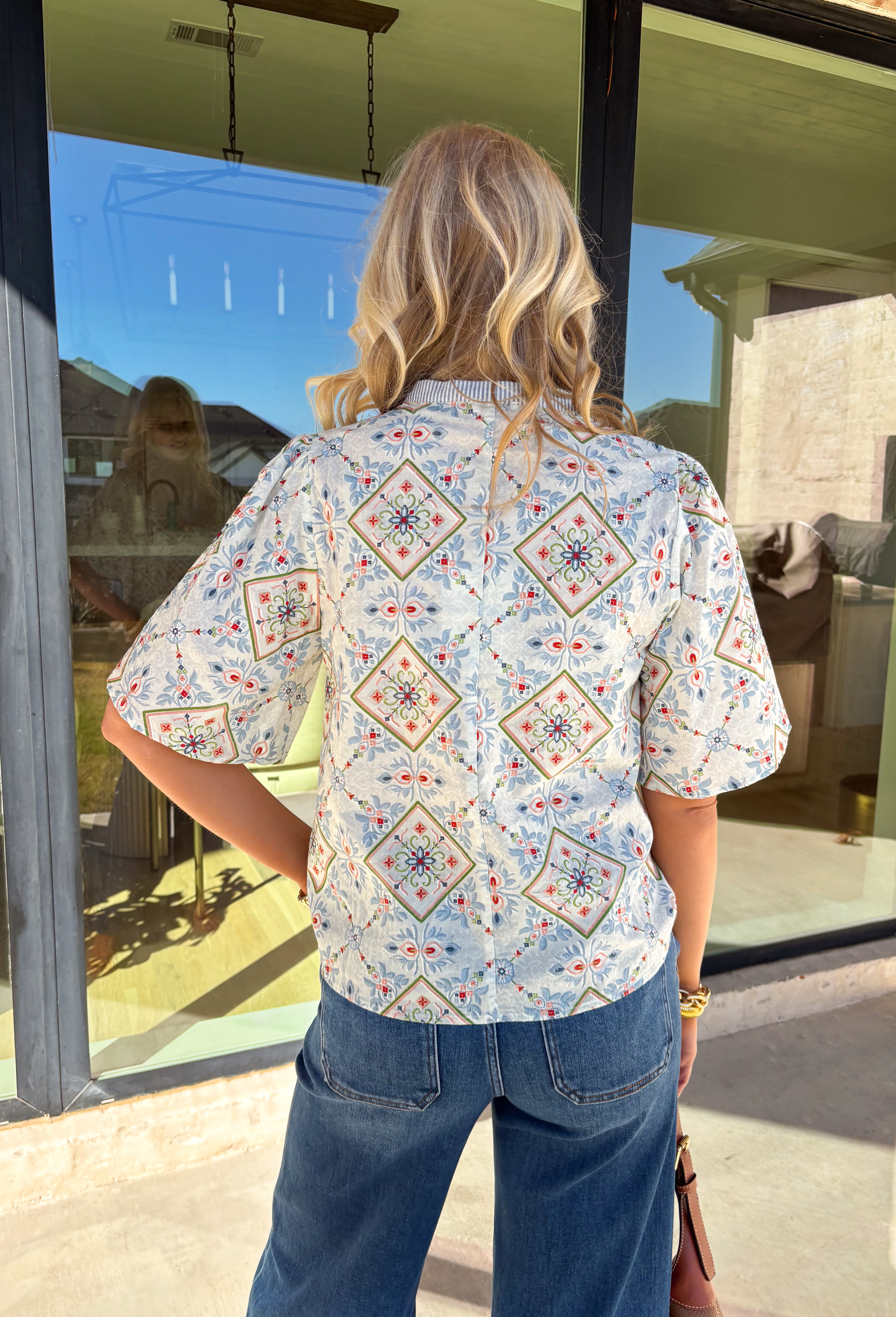 Bright, playful, and made for spring days, this off-white short sleeve top by Voy is an instant mood booster. Featuring a colorful floral print with pops of light blue, green, pink, and red, it brings the perfect burst of color to your everyday lineup. Light blue and white striped detailing along the top adds a fun contrast, while the orange rickrack trim gives it the cutest vintage-inspired finish. Made from breathable cotton, this top is easy to wear and effortless to style all season long.