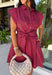 This striped dress brings together rich autumn colors and timeless style for a look you'll love all season long. Featuring brown and vibrant fuchsia stripes, it adds a fun pop of color while still feeling perfectly fall-ready. The front button closure and flattering waist tie create a polished silhouette, while the elastic back waist offers a comfortable fit you'll appreciate from morning to night. Finished with cap sleeves, side pockets, and a fully lined design.