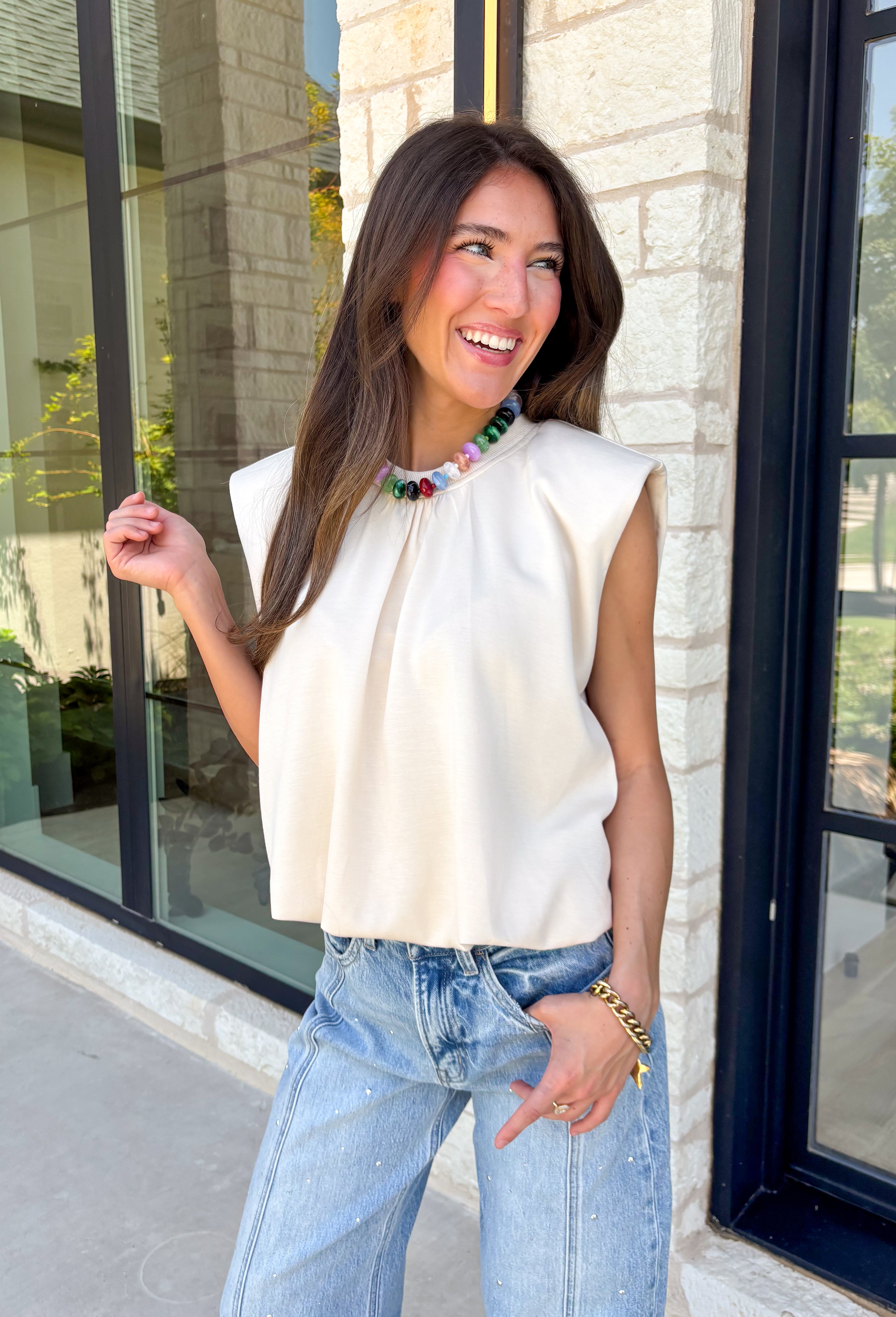Say hello to your new favorite neutral top! Designed with a softly gathered round neckline and an elastic hem, it creates a flattering silhouette that's both comfortable and polished. The cap sleeves make it perfect for layering under cardigans, blazers, or denim jackets as the temperatures begin to cool, while the buttery-soft knit fabric makes it one you'll want to wear on repeat.