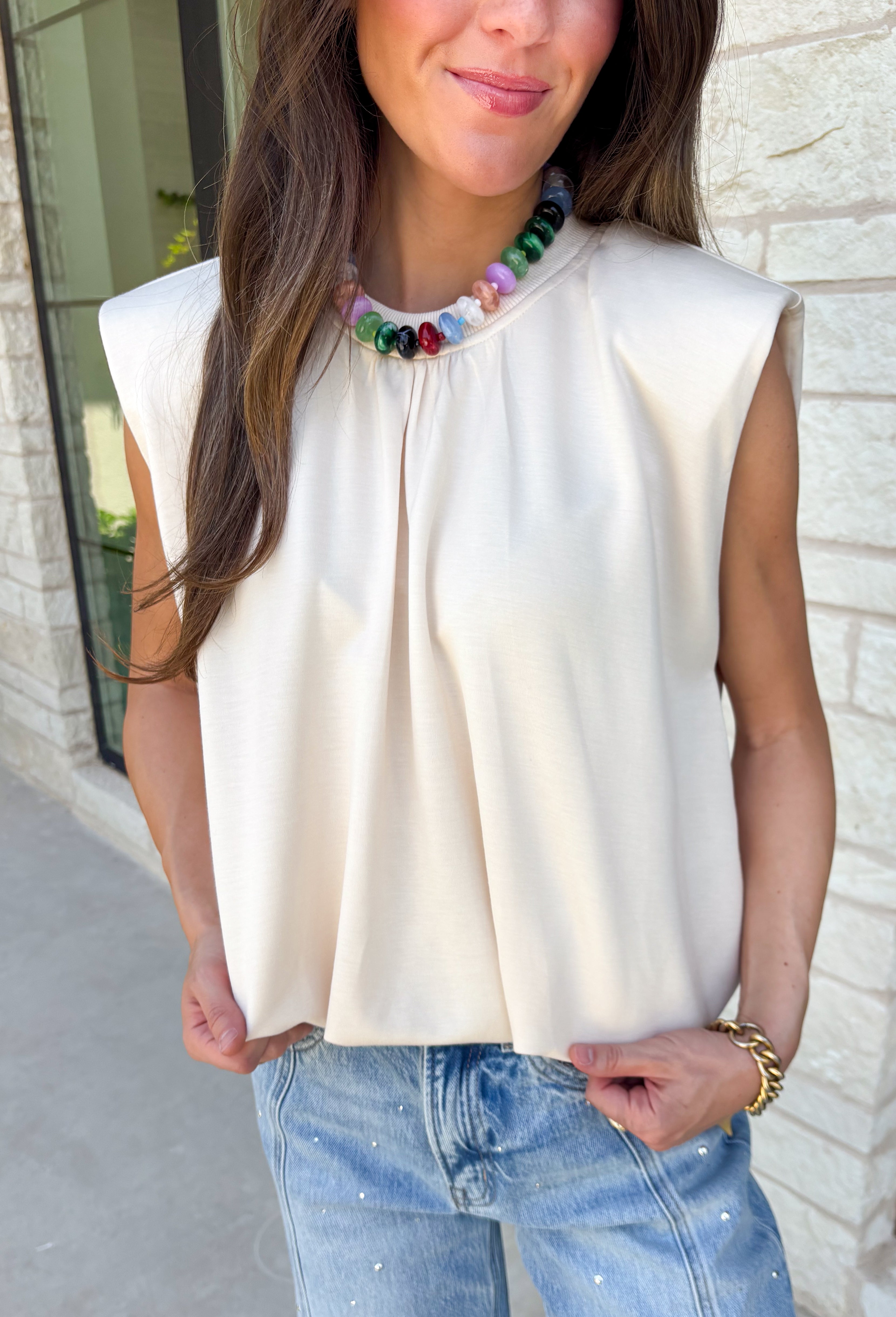 Say hello to your new favorite neutral top! Designed with a softly gathered round neckline and an elastic hem, it creates a flattering silhouette that's both comfortable and polished. The cap sleeves make it perfect for layering under cardigans, blazers, or denim jackets as the temperatures begin to cool, while the buttery-soft knit fabric makes it one you'll want to wear on repeat.