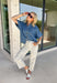 A timeless denim shirt is a wardrobe essential, and this one is designed to go with everything. Crafted from soft medium wash denim with warm tan contrast stitching throughout, this classic button-down top offers effortless style for every season. The collared neckline and front pocket give it a timeless look, while the short sleeves make it perfect for layering or wearing on its own. 
