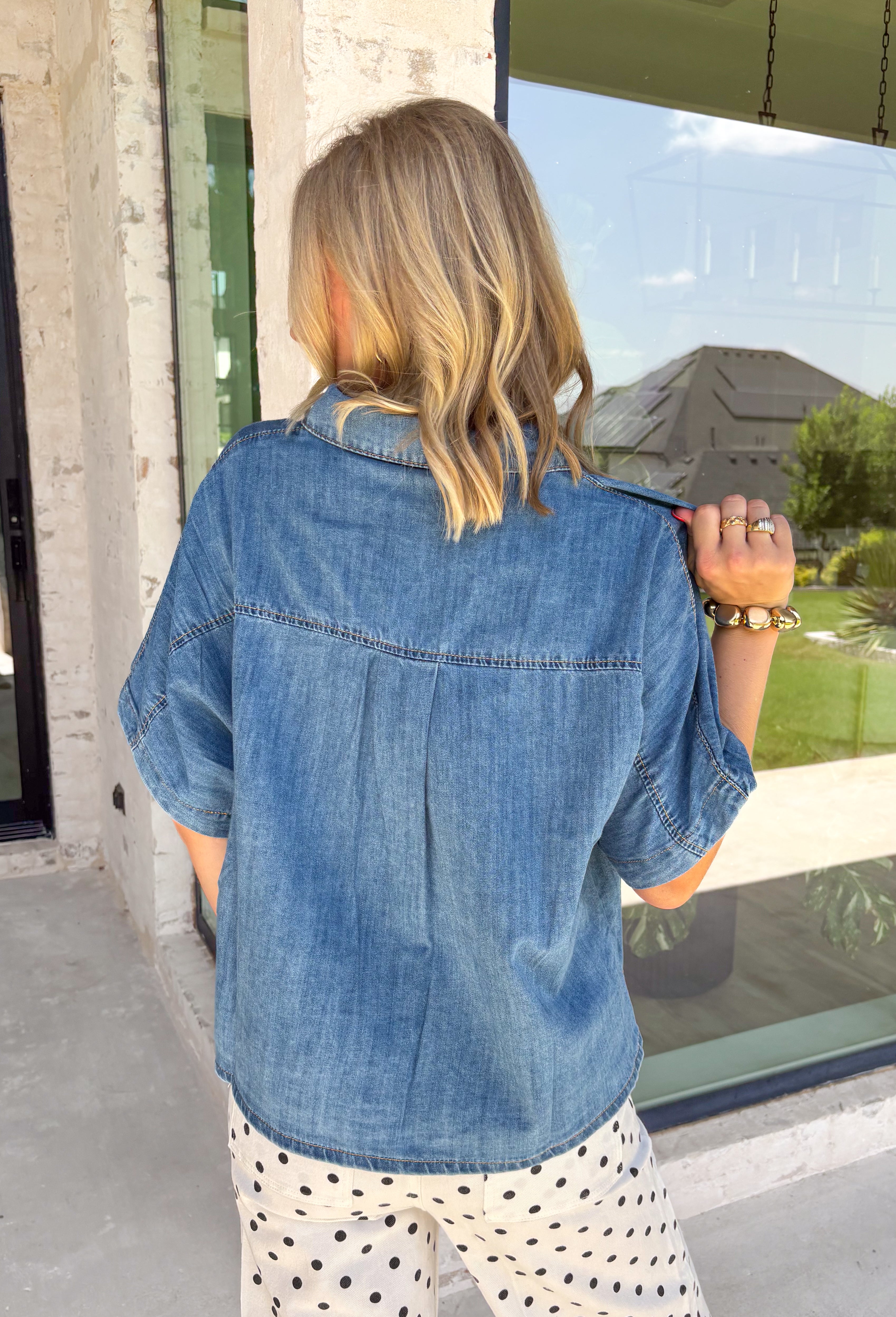 A timeless denim shirt is a wardrobe essential, and this one is designed to go with everything. Crafted from soft medium wash denim with warm tan contrast stitching throughout, this classic button-down top offers effortless style for every season. The collared neckline and front pocket give it a timeless look, while the short sleeves make it perfect for layering or wearing on its own. 