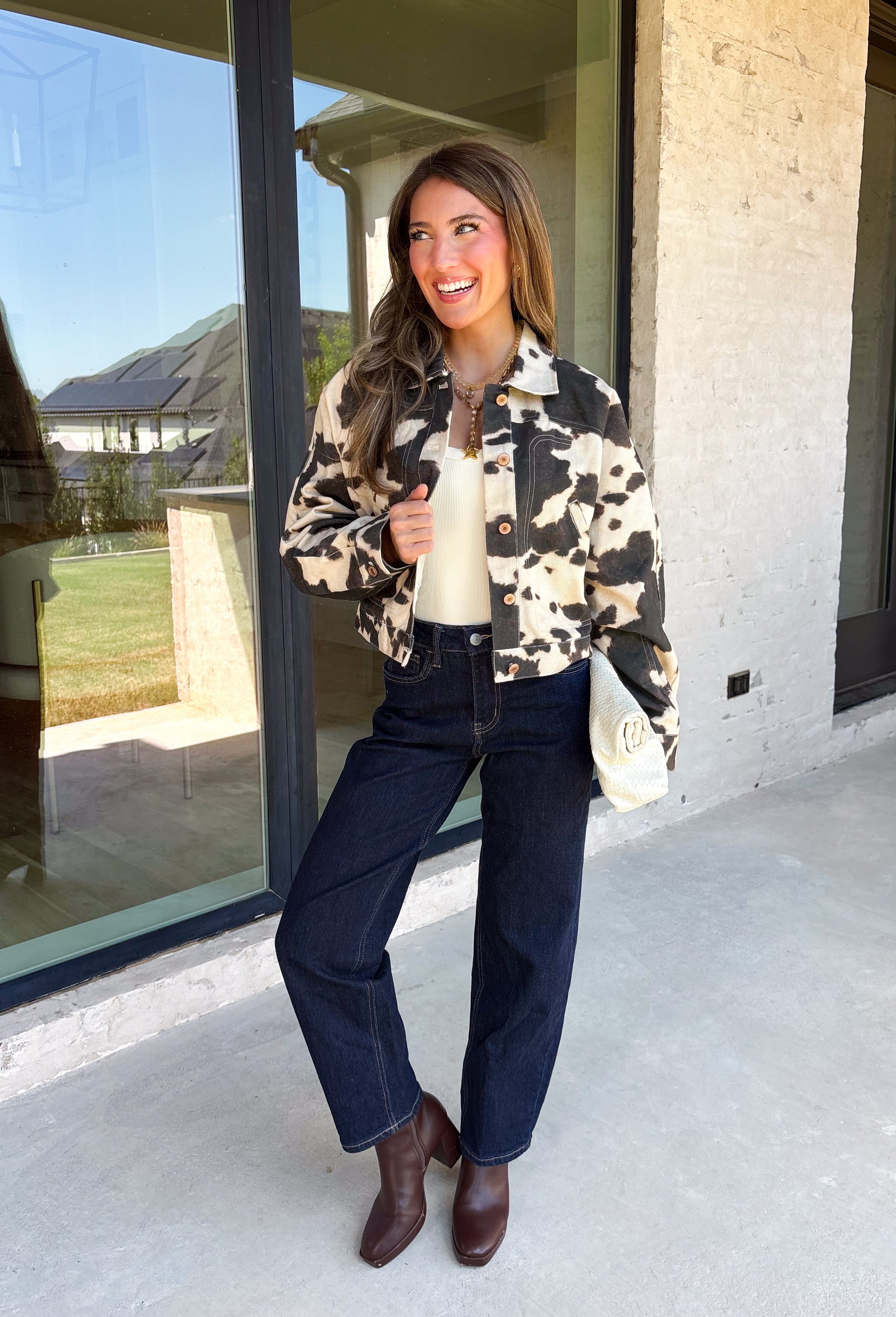 Add a little western-inspired flair to your layering collection with this standout denim jacket from Entro. Designed with a striking cream and black cowhide-inspired print, this timeless piece brings the perfect mix of classic denim styling and bold personality. The collared neckline and button-front closure create a polished, everyday look, while the front pockets add both style and function.