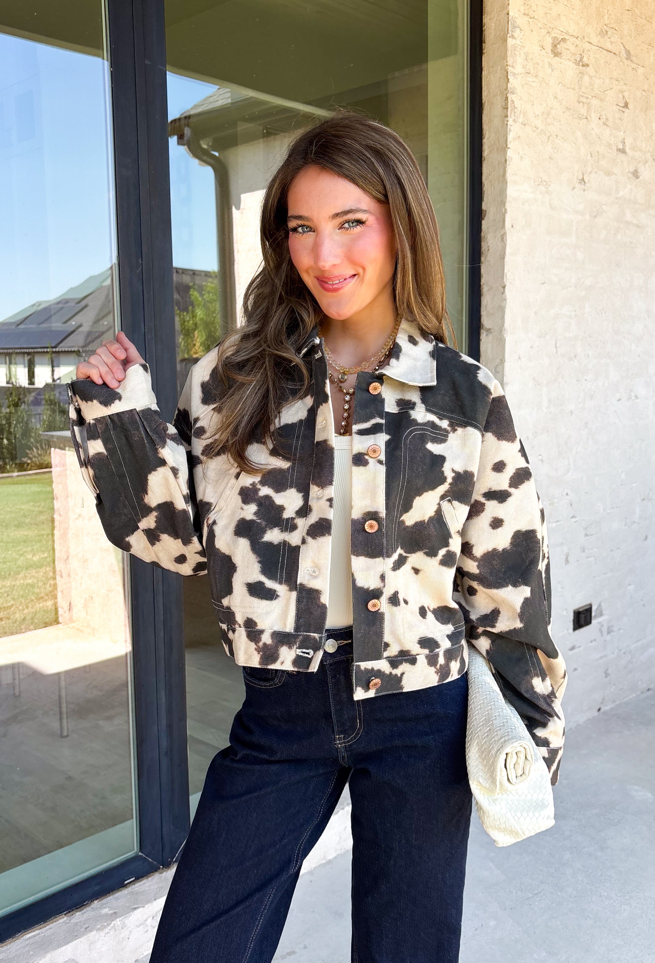 Add a little western-inspired flair to your layering collection with this standout denim jacket from Entro. Designed with a striking cream and black cowhide-inspired print, this timeless piece brings the perfect mix of classic denim styling and bold personality. The collared neckline and button-front closure create a polished, everyday look, while the front pockets add both style and function.