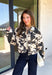 Add a little western-inspired flair to your layering collection with this standout denim jacket from Entro. Designed with a striking cream and black cowhide-inspired print, this timeless piece brings the perfect mix of classic denim styling and bold personality. The collared neckline and button-front closure create a polished, everyday look, while the front pockets add both style and function.