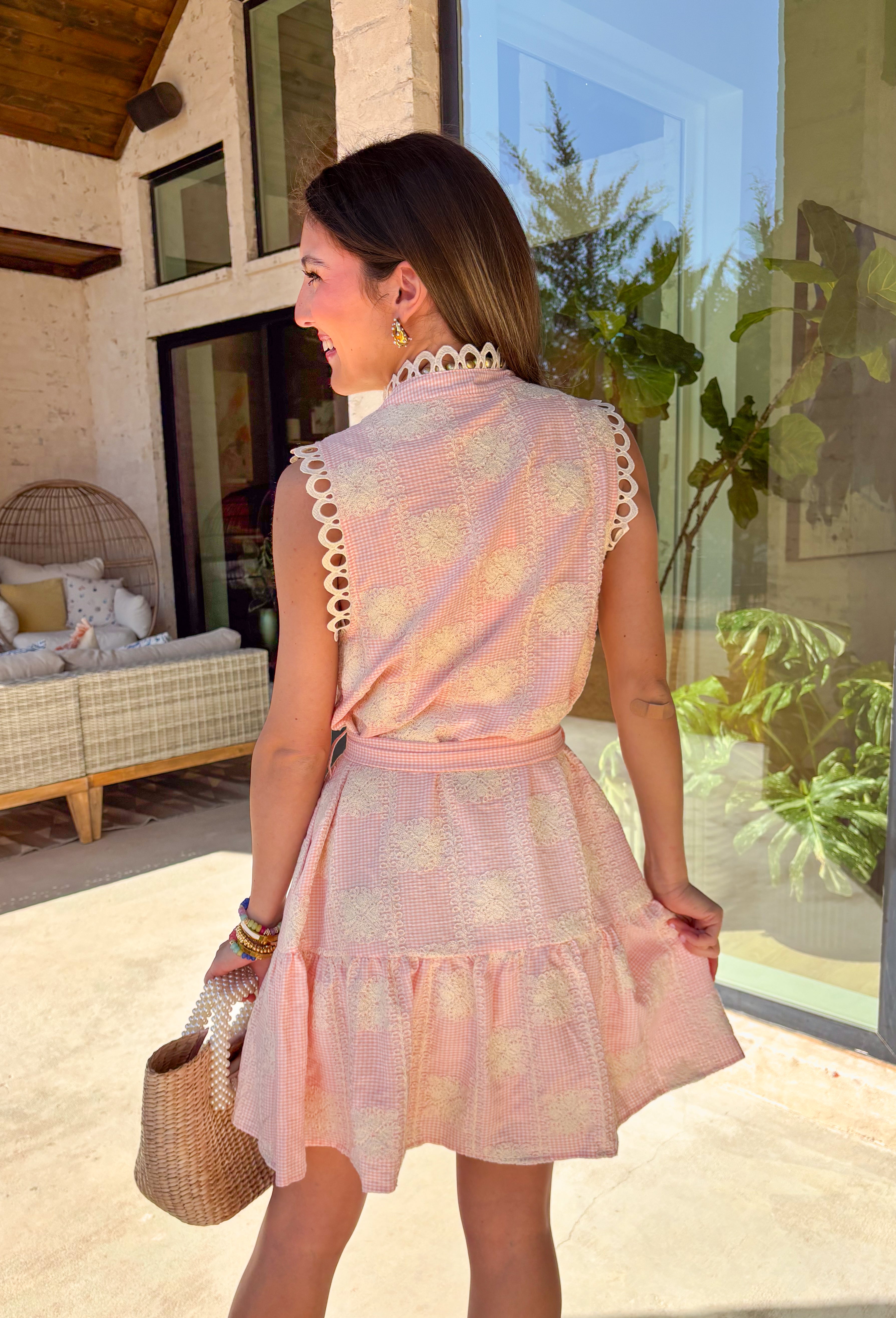 Sweet, romantic, and made for spring moments, this light pink and white mini gingham dress by Entro is full of charming details. Designed with a sleeveless silhouette, it features cream lace throughout for beautiful texture, along with delicate crochet lace trim at the neckline and sleeves. Pearl button details add a soft, vintage-inspired touch, while the tiered skirt gives it easy movement. Fully lined and lightweight, this dress is perfect for sunny days, brunch dates, and spring celebrations.