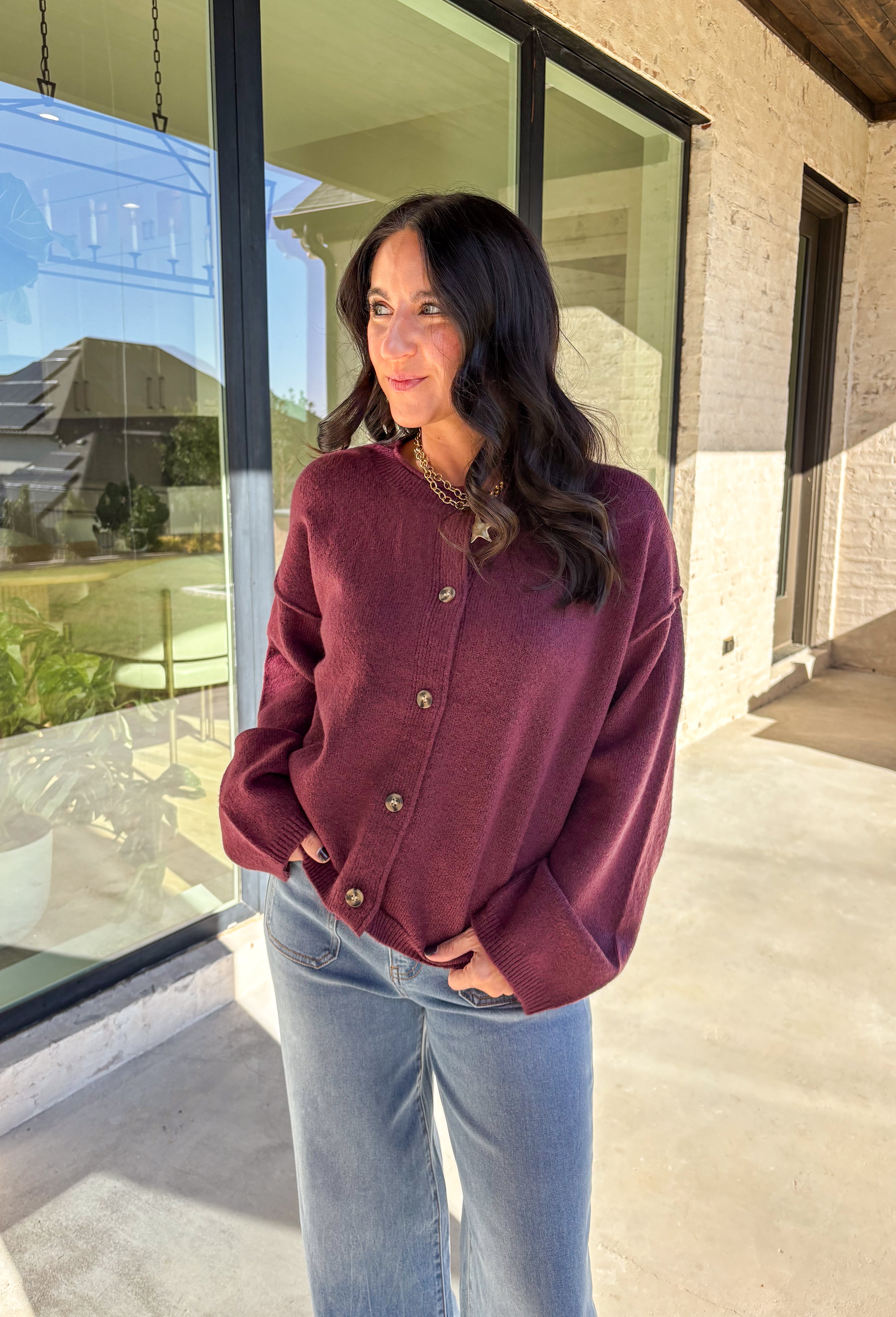 This burgundy button-down cardigan by Double Zero is the ultimate cozy classic. The soft knit fabric and rich fall hue make it an effortless layering piece for cooler days. Whether you’re dressing it up with a blouse or keeping it casual with jeans and a tee, this timeless cardigan adds warmth and style to any outfit.