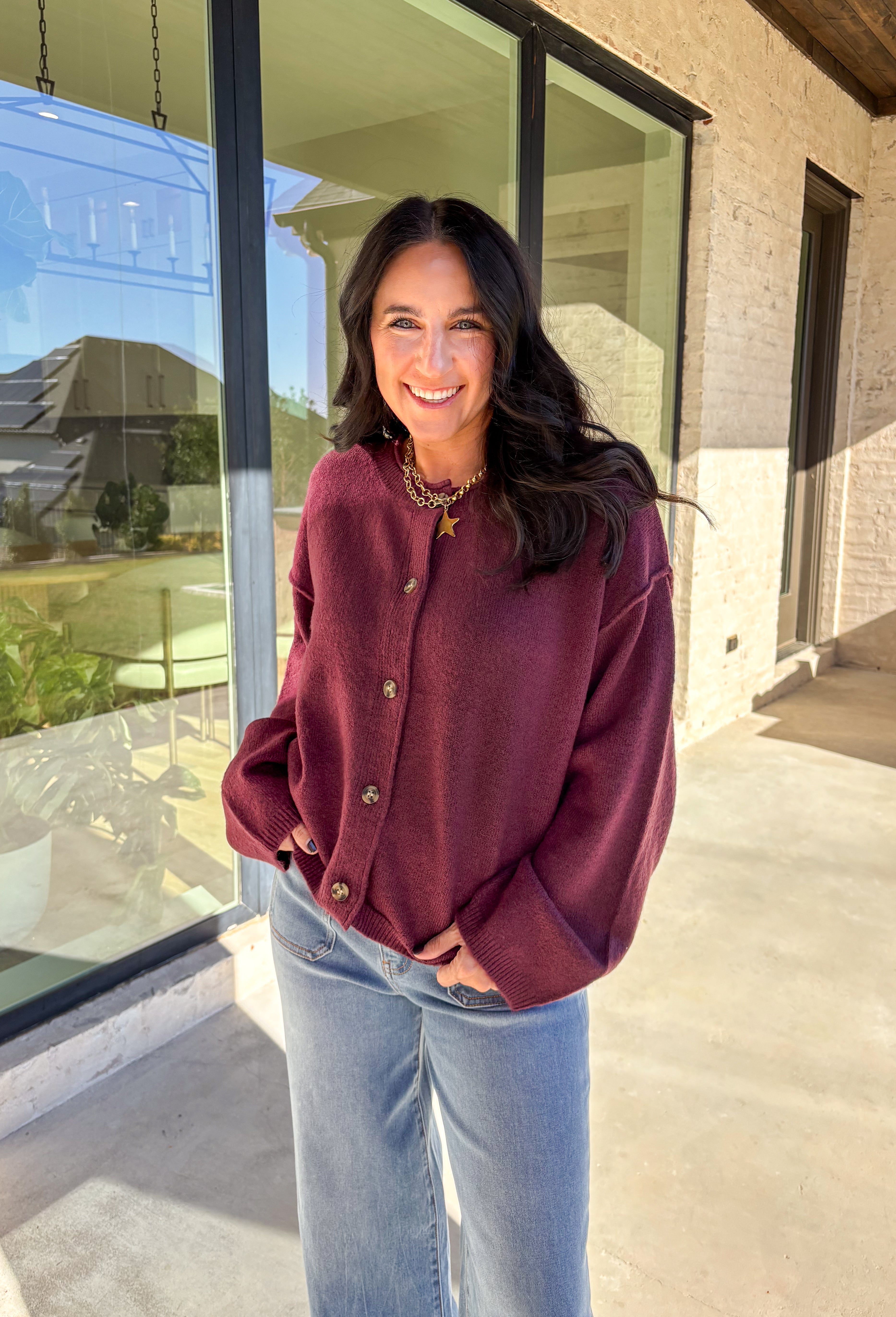 This burgundy button-down cardigan by Double Zero is the ultimate cozy classic. The soft knit fabric and rich fall hue make it an effortless layering piece for cooler days. Whether you’re dressing it up with a blouse or keeping it casual with jeans and a tee, this timeless cardigan adds warmth and style to any outfit.