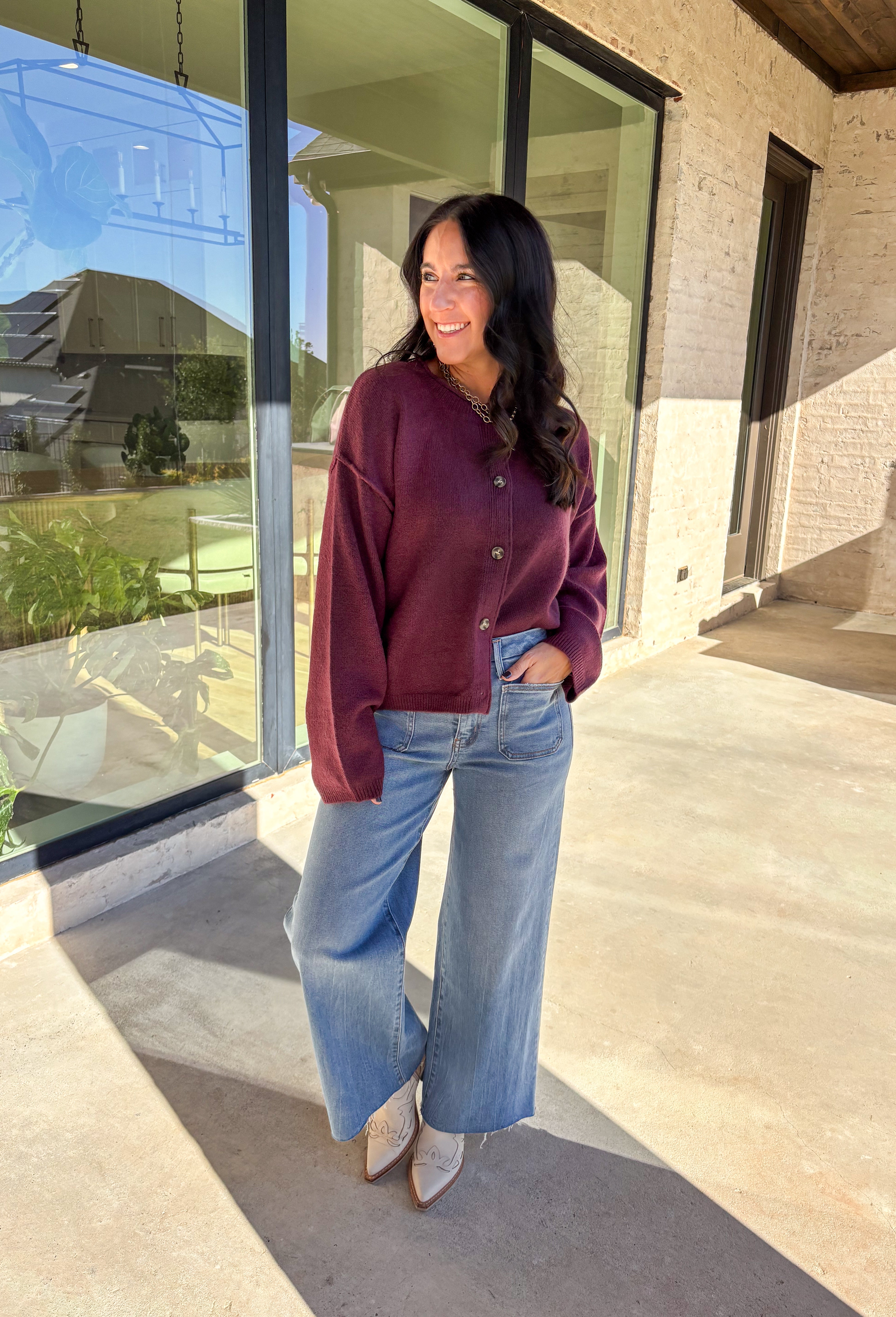 This burgundy button-down cardigan by Double Zero is the ultimate cozy classic. The soft knit fabric and rich fall hue make it an effortless layering piece for cooler days. Whether you’re dressing it up with a blouse or keeping it casual with jeans and a tee, this timeless cardigan adds warmth and style to any outfit.