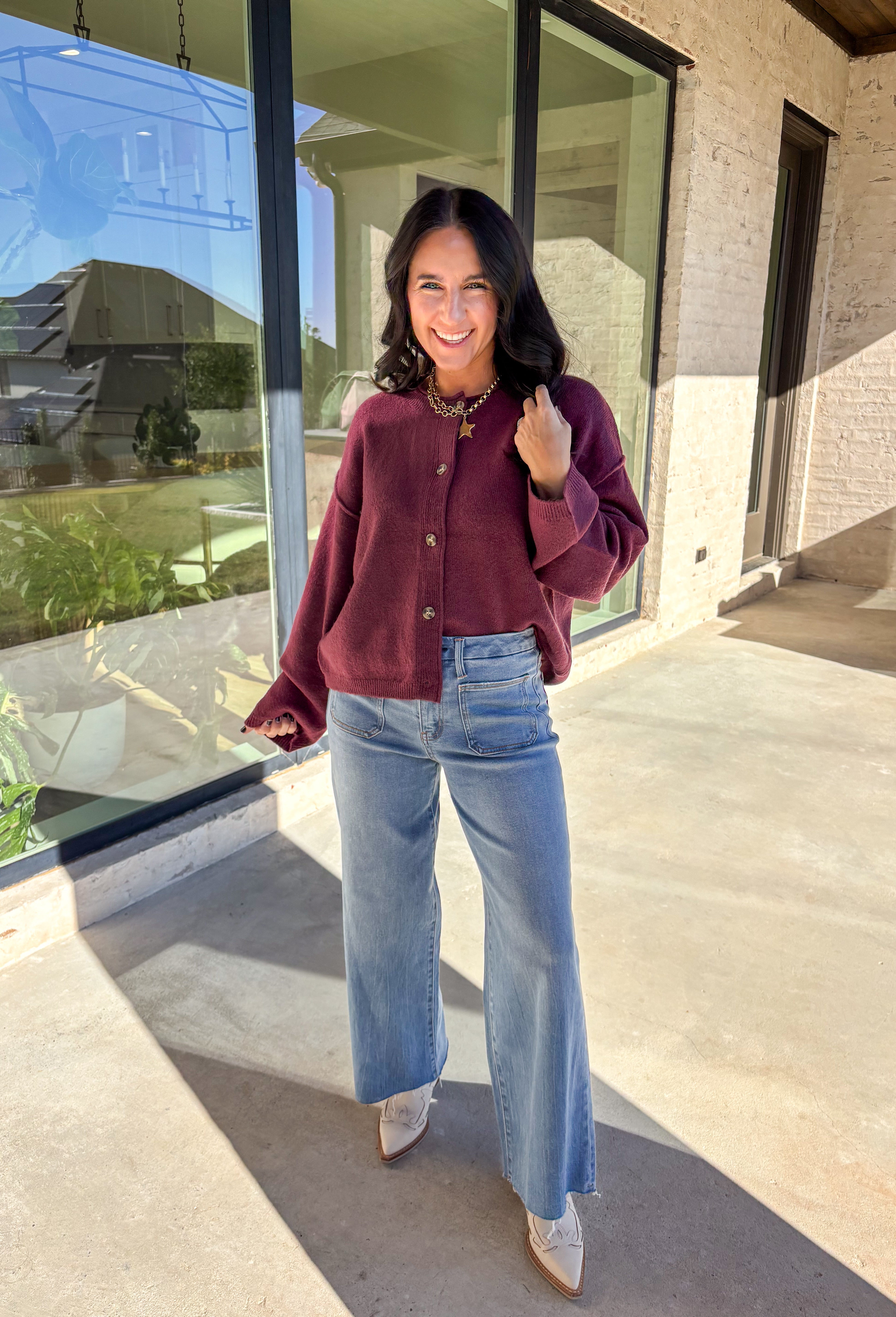 This burgundy button-down cardigan by Double Zero is the ultimate cozy classic. The soft knit fabric and rich fall hue make it an effortless layering piece for cooler days. Whether you’re dressing it up with a blouse or keeping it casual with jeans and a tee, this timeless cardigan adds warmth and style to any outfit.