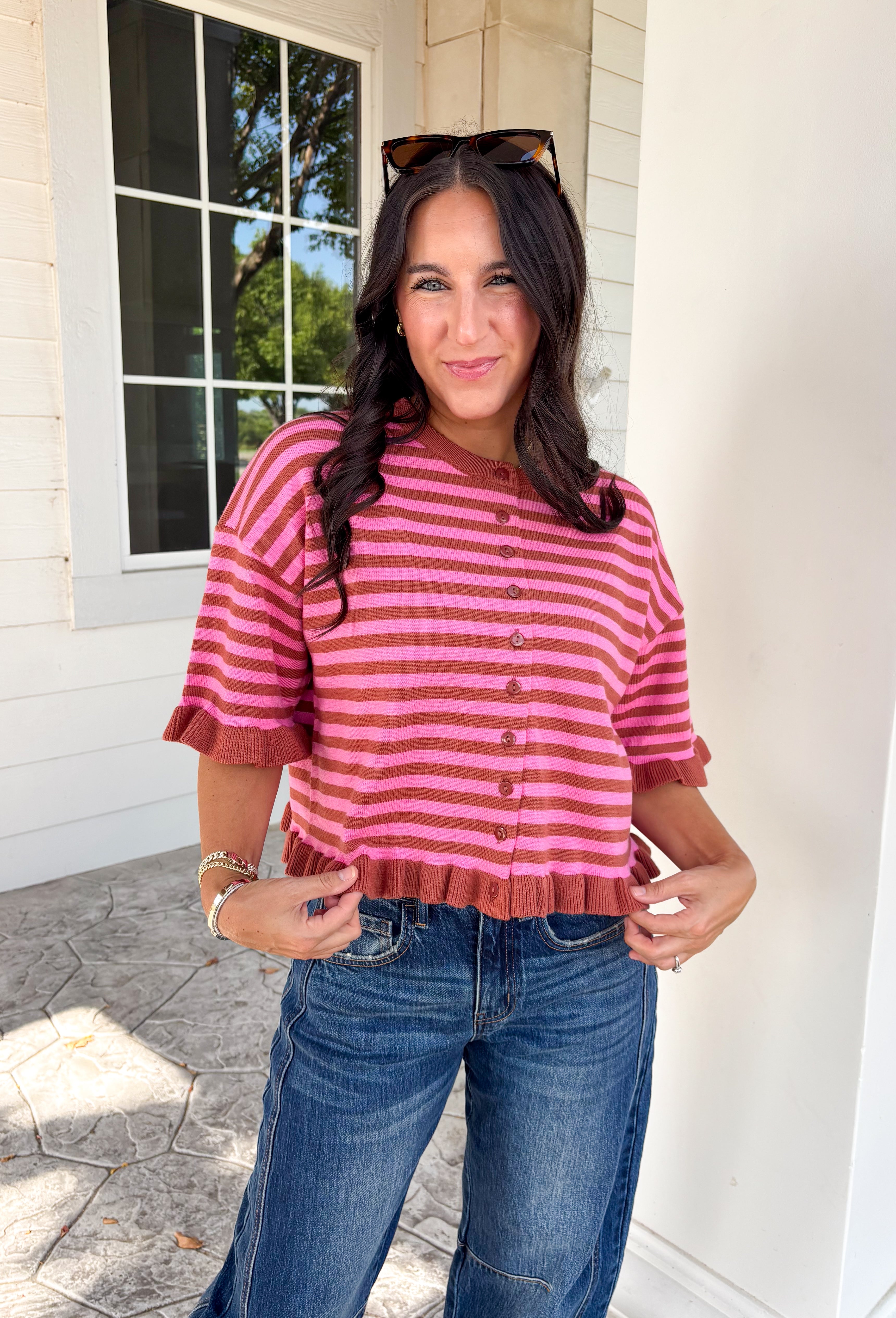 Sweet details and rich fall colors make this knit cardigan an instant favorite. Featuring warm brown and pink stripes, this lightweight cardigan brings the perfect touch of cozy charm to your autumn wardrobe. The ruffle trim on the sleeves and hem adds a feminine finish, while the button-down front lets you wear it as a cardigan or buttoned up as a sweater. It's the perfect transitional knit for everything from office days to weekend coffee runs and crisp fall afternoons.