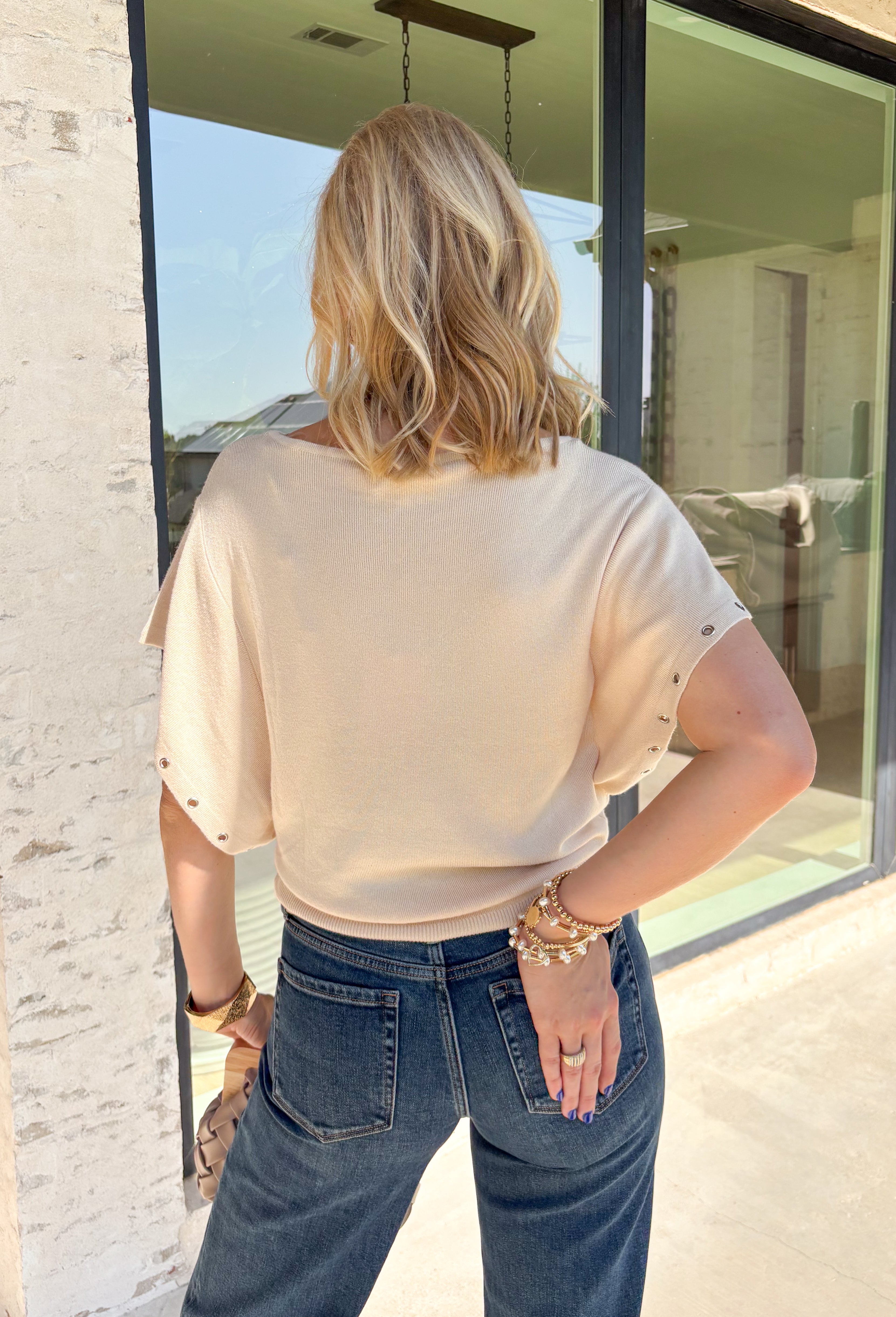 Simple, timeless, and elevated with just the right amount of detail, this ecru knit top is a fall wardrobe essential! Crafted from a soft, lightweight knit, this versatile piece features chic grommet detailing on the sleeves for a modern touch that sets it apart. The classic round neckline makes it easy to style with everything from your favorite denim to tailored trousers, while the cozy feel keeps it comfortable all day long.