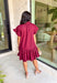 This burgundy ruffle mini dress is giving effortless charm with a touch of flirty flair. The playful ruffle hem and dainty button-front detail add just the right amount of movement, while side pockets keep it practical (because we all love a good pocket moment). Whether you’re headed to a fall brunch or layering it with boots and a denim jacket, this dress is a go-to for cozy and cute autumn style.