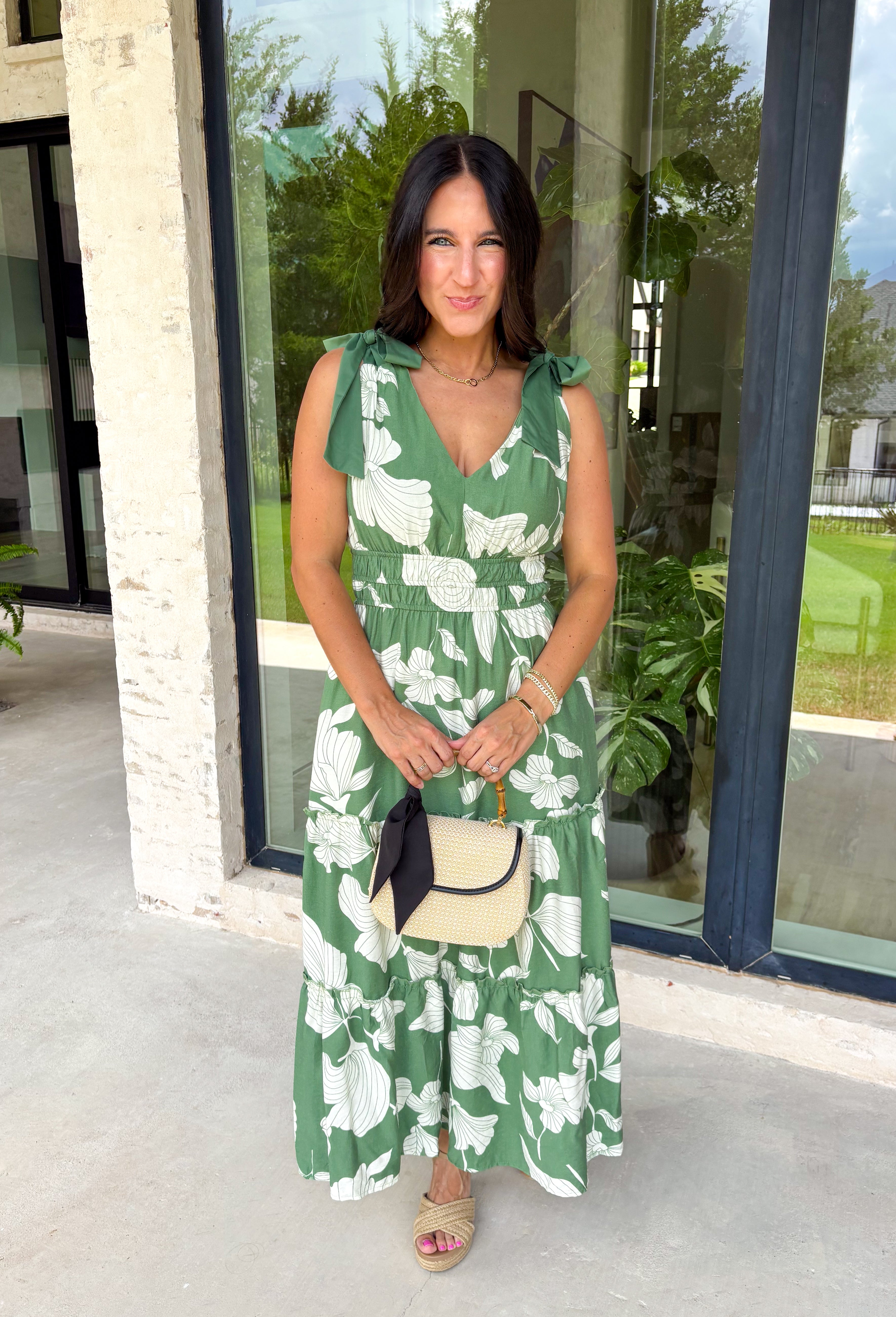 This darker green floral midi dress is such a dreamy, easy piece for summer days! The neutral floral print keeps it soft and wearable, while the tiered ruffle details add beautiful movement and dimension. Designed with adjustable tie straps and an elastic waist, it gives you that flattering, comfortable fit you’ll love all day long. The v-neckline adds a feminine touch, and of course—side pockets make it even better. Fully lined and lightweight, it’s perfect for everything from brunch to vacation dinners. 
