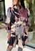 Celebrate the beauty of the season in this stunning eyelet dress from Entro. Designed in a gorgeous fall-inspired print featuring shades of black, brown, tan, gray, off-white, and a subtle pop of pink, this timeless dress is full of feminine charm. Delicate eyelet detailing adds beautiful texture, while the decorative front button accents and matching self-tie belt create a polished, flattering silhouette. 