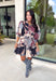 Celebrate the beauty of the season in this stunning eyelet dress from Entro. Designed in a gorgeous fall-inspired print featuring shades of black, brown, tan, gray, off-white, and a subtle pop of pink, this timeless dress is full of feminine charm. Delicate eyelet detailing adds beautiful texture, while the decorative front button accents and matching self-tie belt create a polished, flattering silhouette. 