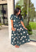 Timeless style meets effortless charm in this beautiful polka dot midi dress. Featuring a rich hunter green backdrop with a bold neutral polka dot print, this classic silhouette is one you'll love wearing year after year. The button-front design and adjustable self-tie waist create a flattering, feminine fit, while the puff sleeves add just the right amount of romantic detail. Complete with side pockets and a fully lined design, this cotton dress is as practical as it is polished.