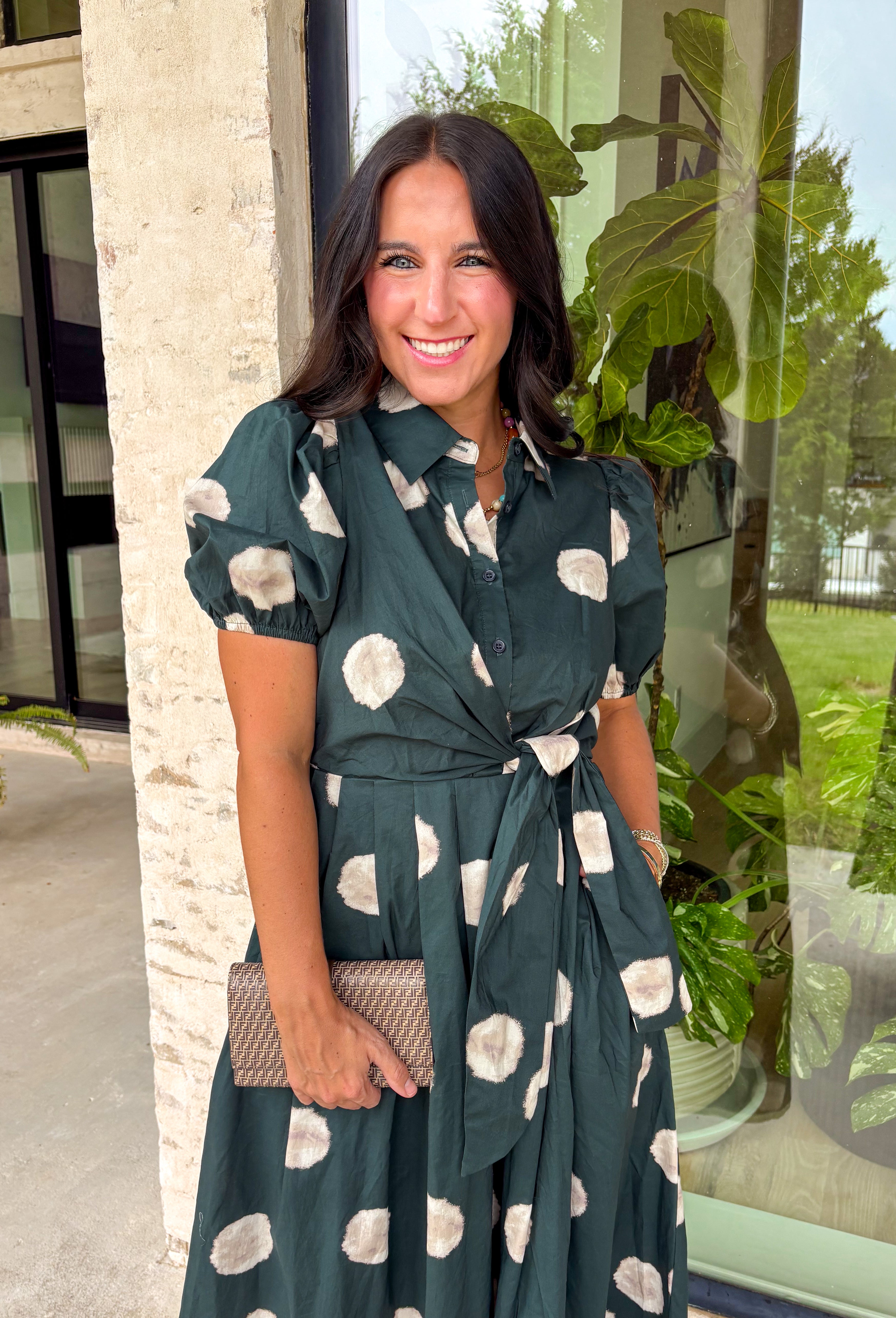Timeless style meets effortless charm in this beautiful polka dot midi dress. Featuring a rich hunter green backdrop with a bold neutral polka dot print, this classic silhouette is one you'll love wearing year after year. The button-front design and adjustable self-tie waist create a flattering, feminine fit, while the puff sleeves add just the right amount of romantic detail. Complete with side pockets and a fully lined design, this cotton dress is as practical as it is polished.