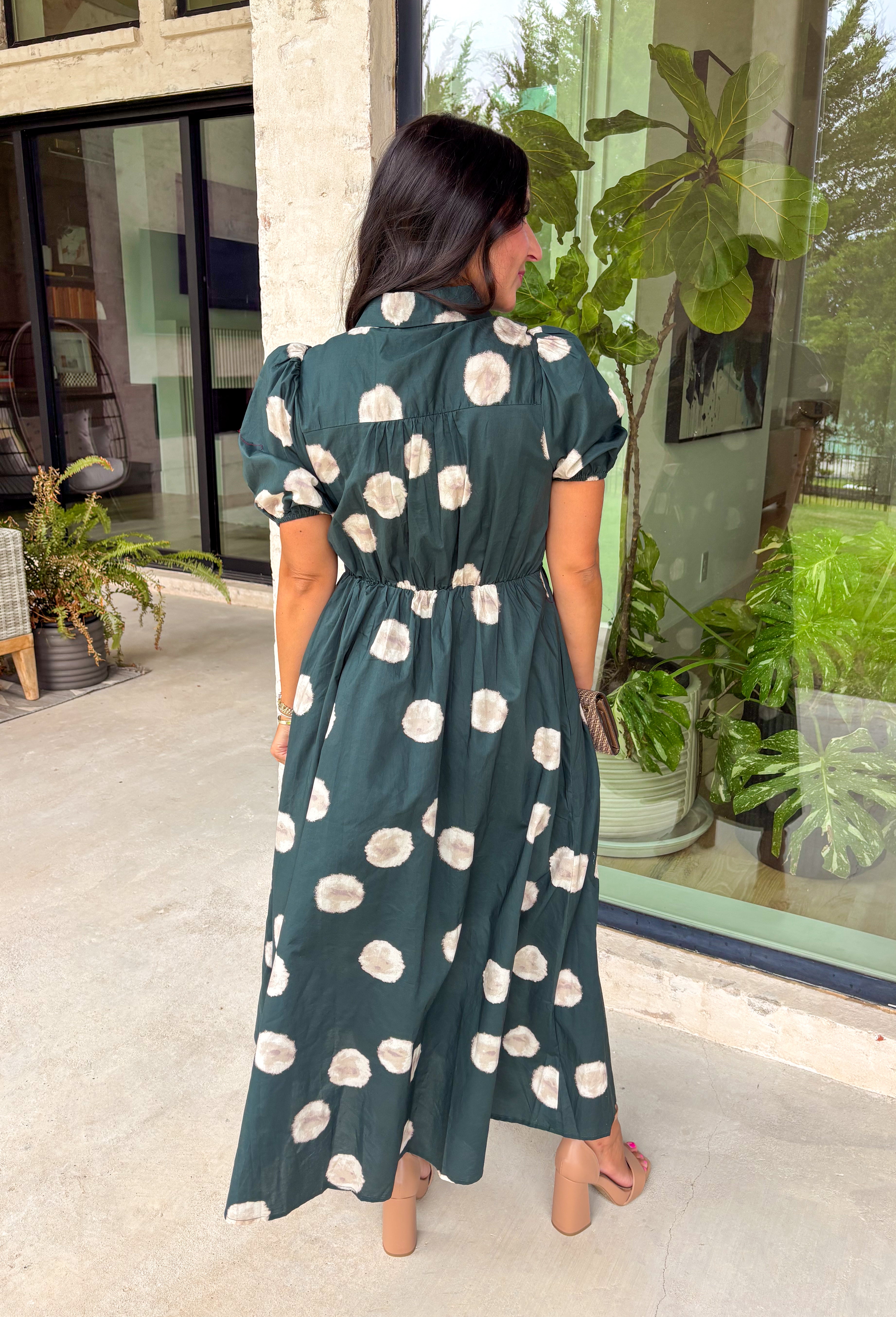 Timeless style meets effortless charm in this beautiful polka dot midi dress. Featuring a rich hunter green backdrop with a bold neutral polka dot print, this classic silhouette is one you'll love wearing year after year. The button-front design and adjustable self-tie waist create a flattering, feminine fit, while the puff sleeves add just the right amount of romantic detail. Complete with side pockets and a fully lined design, this cotton dress is as practical as it is polished.