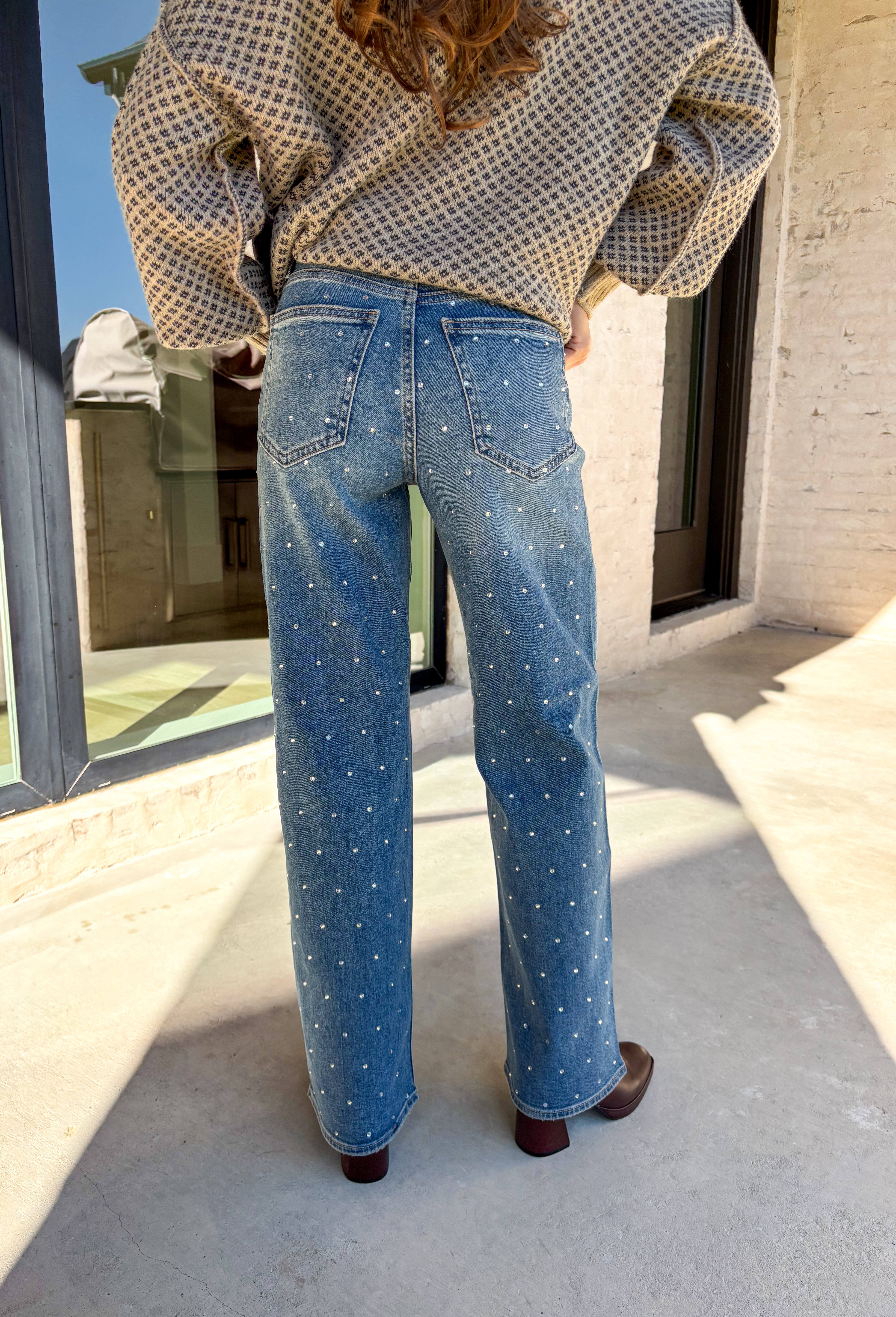 Make your winter wardrobe shine with these statement-making straight jeans by Just Black Denim. Designed in a classic medium wash with a flattering high rise, these standout denim gems are covered in silver rhinestones from front to back for the perfect touch of sparkle. With a structured yet comfortable fit, they’re ready for holiday parties, festive nights out, or whenever you want to turn heads.