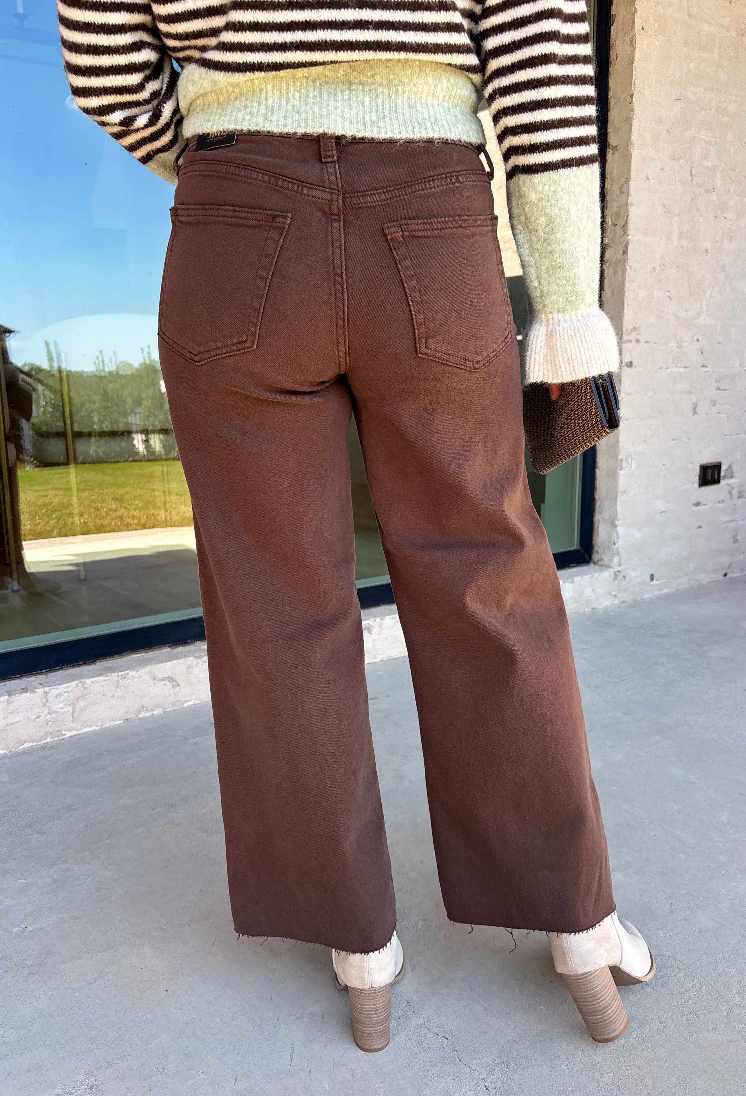 These chocolate brown jeans from Just Black Denim are the perfect blend of timeless style and everyday versatility. Designed with a flattering slim wide leg silhouette, they create an effortlessly elevated look that's easy to dress up or down. The rich chocolate brown color offers a fresh alternative to traditional denim, while the raw edge hem adds a modern finishing touch. Crafted with just the right amount of stretch for all-day comfort, these jeans are sure to become a staple in your fall wardrobe.