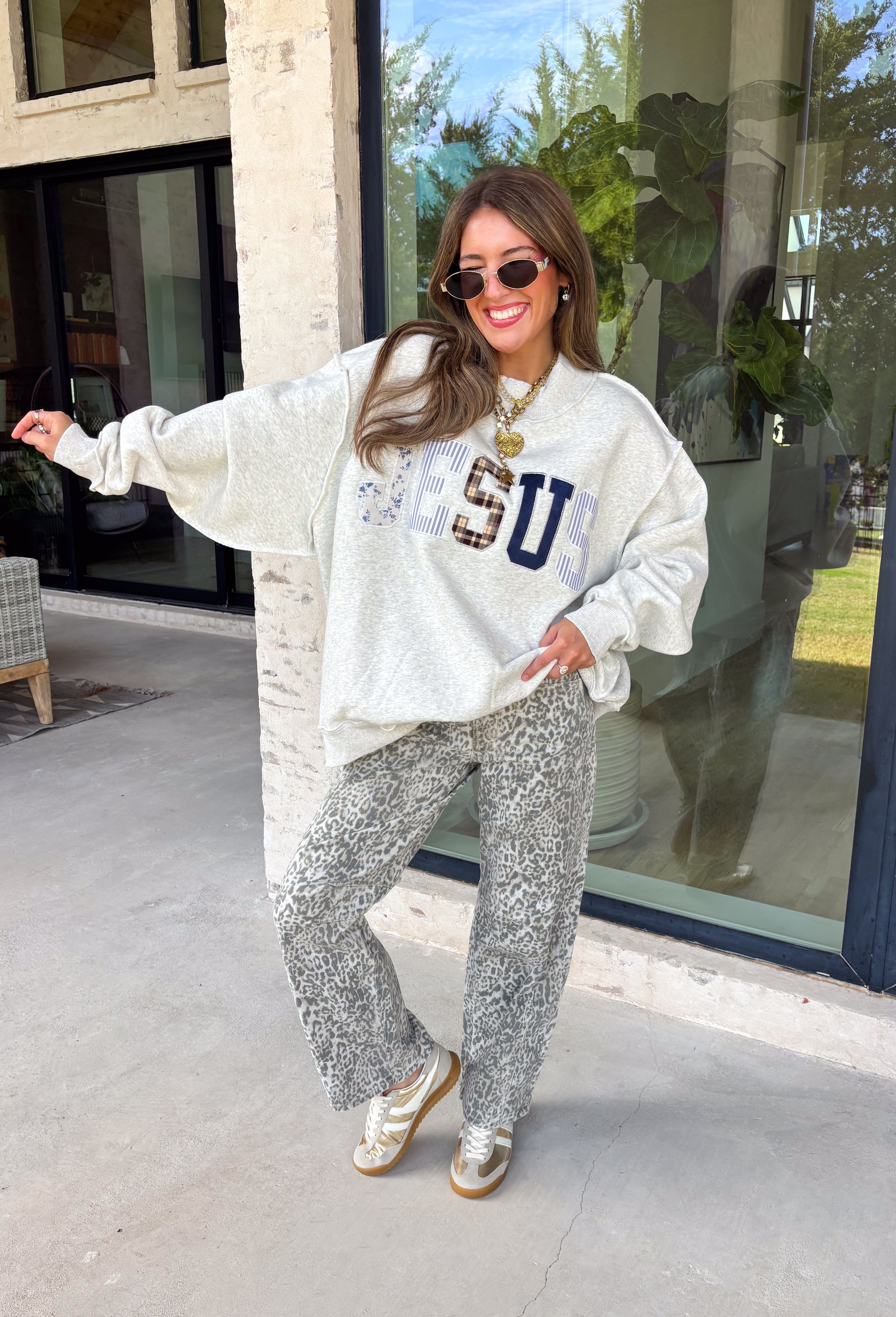Wear your faith in the coziest way with this heather grey “Jesus” pullover from Bucket List. Each letter features its own unique print, including dainty florals, classic stripes, plaid, and solid navy in a soft mix of neutrals and shades of blue. Light grey embroidery outlines each letter for an extra touch of texture that makes the design stand out beautifully against the heather grey background. 