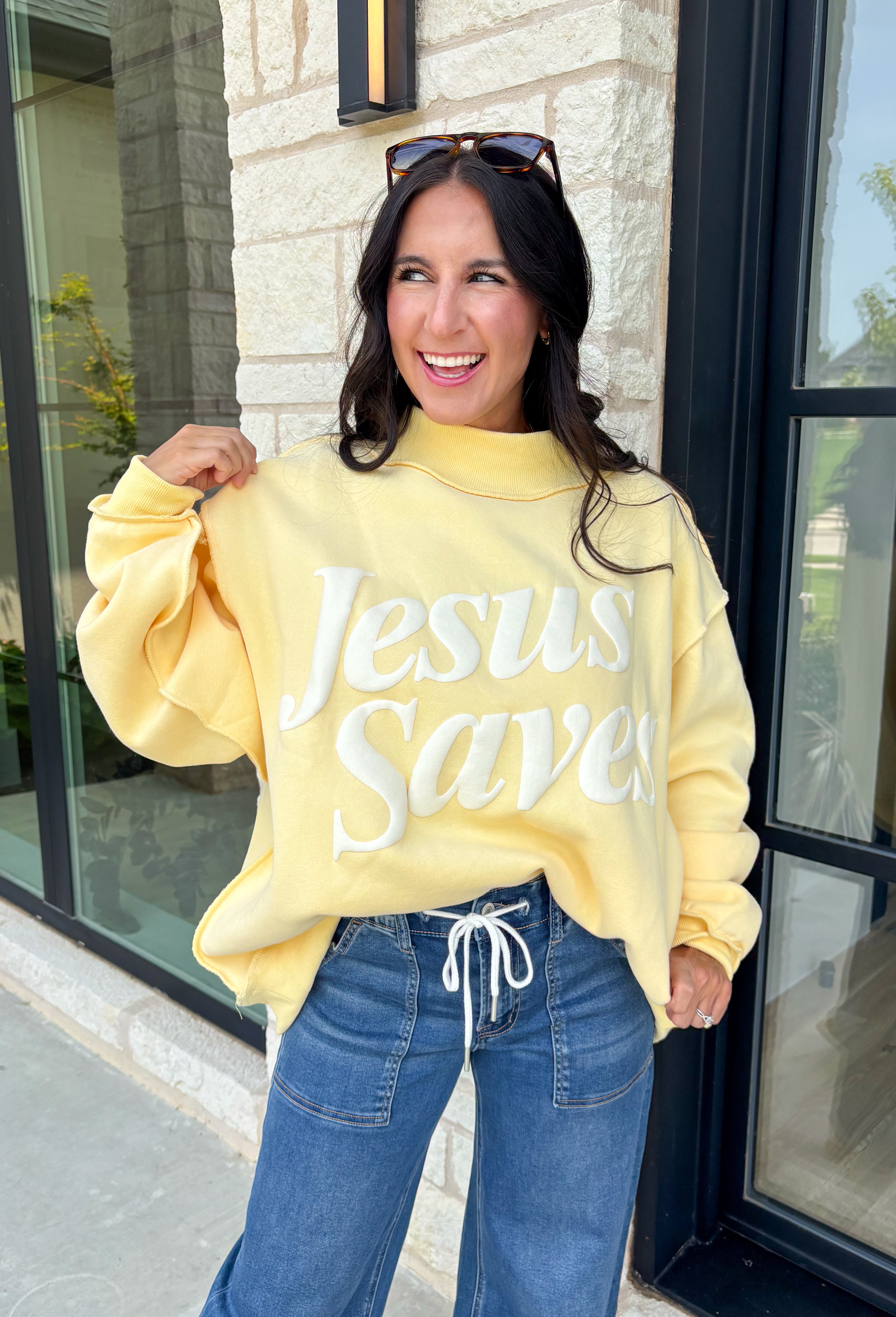 Wrap yourself in faith and comfort with this butter yellow pullover that shares a message worth wearing! Featuring cheerful bubble lettering that reads "Jesus Saves," this cozy soft sweatshirt is the perfect reminder of hope and grace wherever your day takes you. The fleece-lined interior keeps you warm and cozy, while the exposed seam details and ribbed trim give it a laid-back, lived-in feel. 
