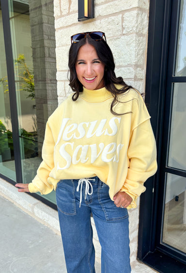 Wrap yourself in faith and comfort with this butter yellow pullover that shares a message worth wearing! Featuring cheerful bubble lettering that reads "Jesus Saves," this cozy soft sweatshirt is the perfect reminder of hope and grace wherever your day takes you. The fleece-lined interior keeps you warm and cozy, while the exposed seam details and ribbed trim give it a laid-back, lived-in feel. 