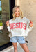 This heathered grey reversible pullover is the cozy, feel-good piece your summer evenings need! Designed with two meaningful looks in one, one side features “Jesus” in coral, while the other side is soft sherpa lined with “God Is Good” for an extra cozy vibe. The mock neck adds a polished touch, making it perfect for breezy nights, early mornings, or lounging in comfort. It’s the kind of piece that feels just as good as it looks—easy, meaningful, and made to wear on repeat. 