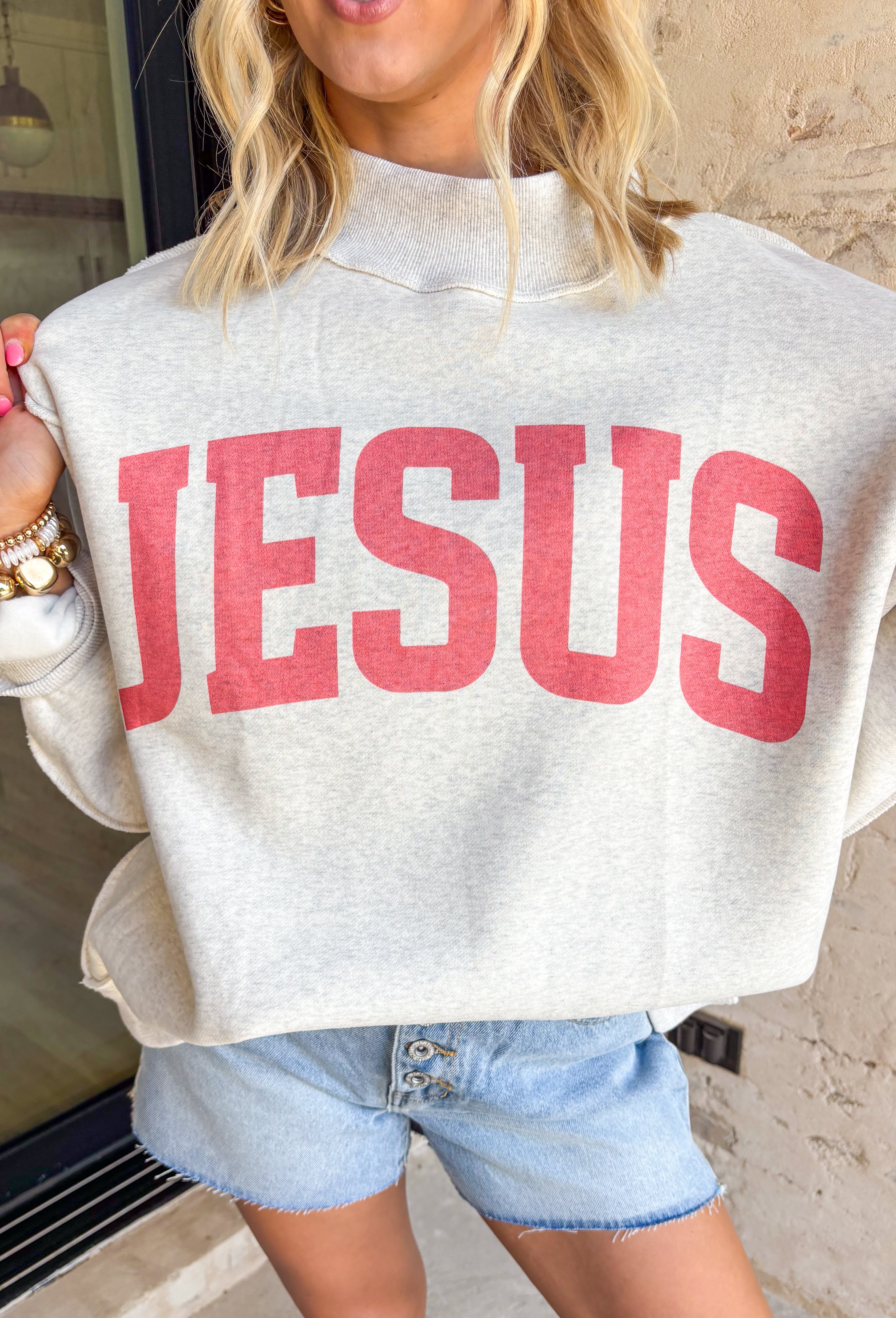 This heathered grey reversible pullover is the cozy, feel-good piece your summer evenings need! Designed with two meaningful looks in one, one side features “Jesus” in coral, while the other side is soft sherpa lined with “God Is Good” for an extra cozy vibe. The mock neck adds a polished touch, making it perfect for breezy nights, early mornings, or lounging in comfort. It’s the kind of piece that feels just as good as it looks—easy, meaningful, and made to wear on repeat. 