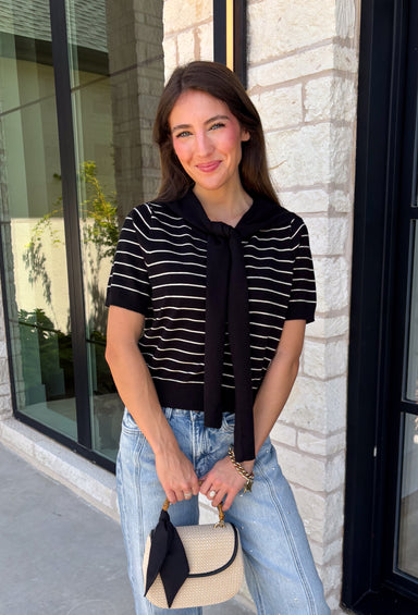 Get the layered look without the extra effort in this cozy short sleeve sweater. Featuring classic black and off white stripes, this knit is designed with an attached layered scarf detail that instantly elevates your outfit. The soft sweater knit keeps you cozy while the short sleeves make it perfect for transitioning through the season and layering under your favorite jackets. Finished with ribbed trim along the neckline, sleeves, and hem.