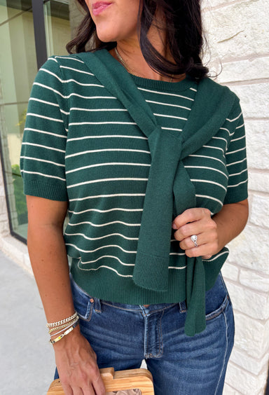 Get the layered look without the extra effort in this cozy short sleeve sweater. Featuring rich hunter green and off white stripes, this knit is designed with an attached layered scarf detail that instantly elevates your outfit. The soft sweater knit keeps you cozy while the short sleeves make it perfect for transitioning through the season and layering under your favorite jackets. 
