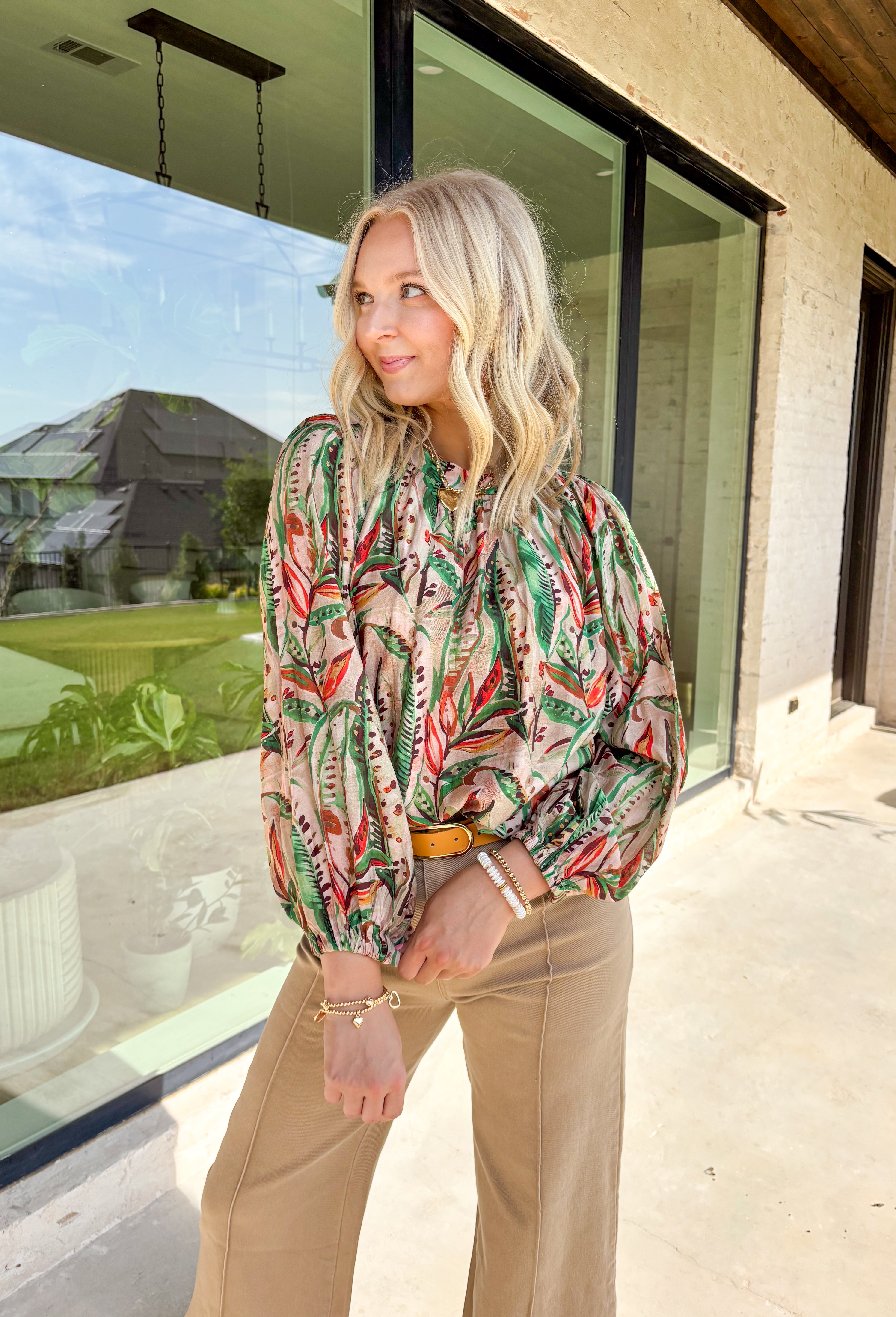 Make a statement this fall with a top that’s as bold as your favorite autumn latte. This neutral long sleeve blouse features a stunning mix of bold leaves and abstract floral patterns in rich seasonal shades of green, brown, orange, red, and tan. The balloon sleeves with elastic cuffs add a touch of drama while keeping things comfy and casual. It’s the perfect top for everything from the office to dinner with the girls.