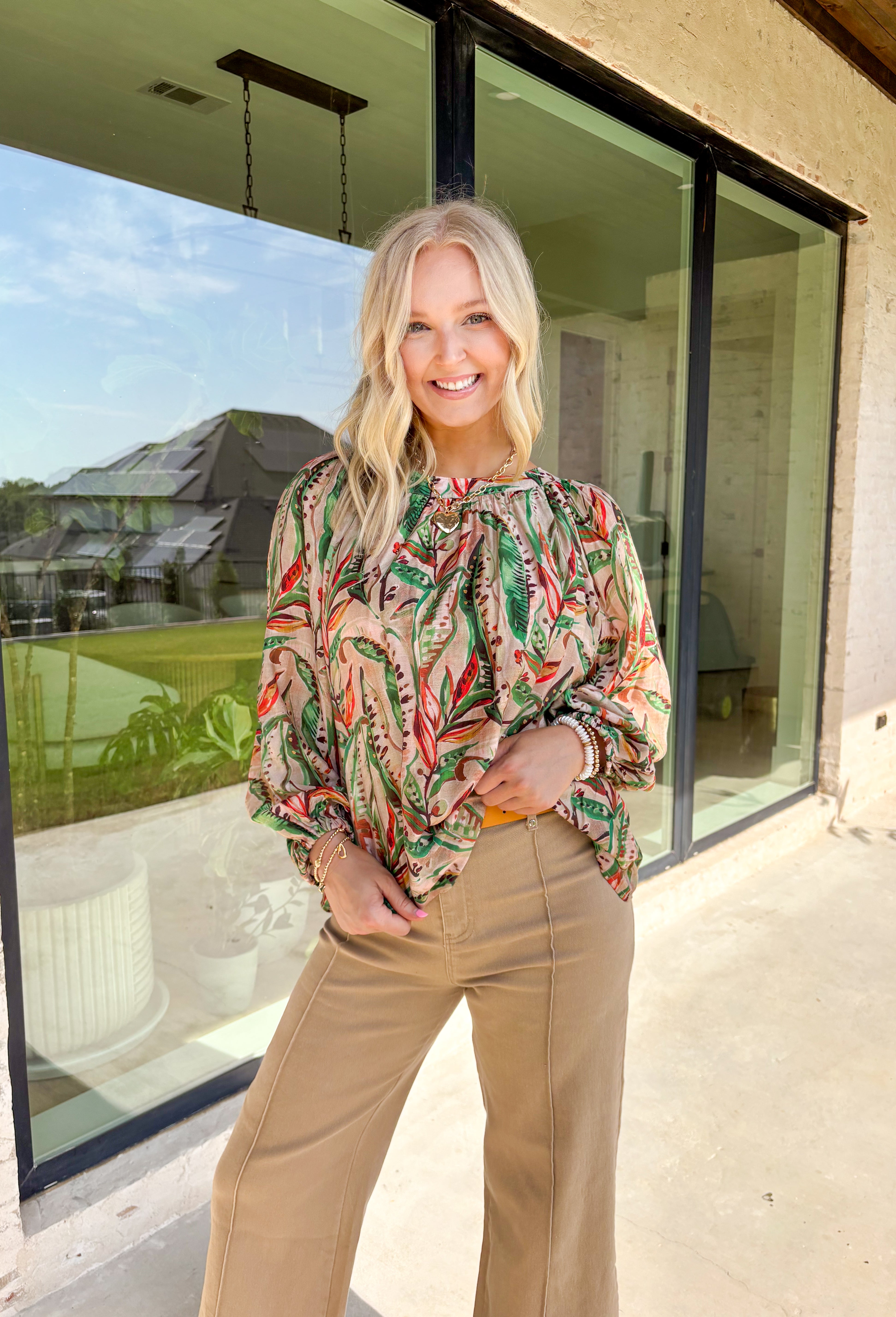 Make a statement this fall with a top that’s as bold as your favorite autumn latte. This neutral long sleeve blouse features a stunning mix of bold leaves and abstract floral patterns in rich seasonal shades of green, brown, orange, red, and tan. The balloon sleeves with elastic cuffs add a touch of drama while keeping things comfy and casual. It’s the perfect top for everything from the office to dinner with the girls.