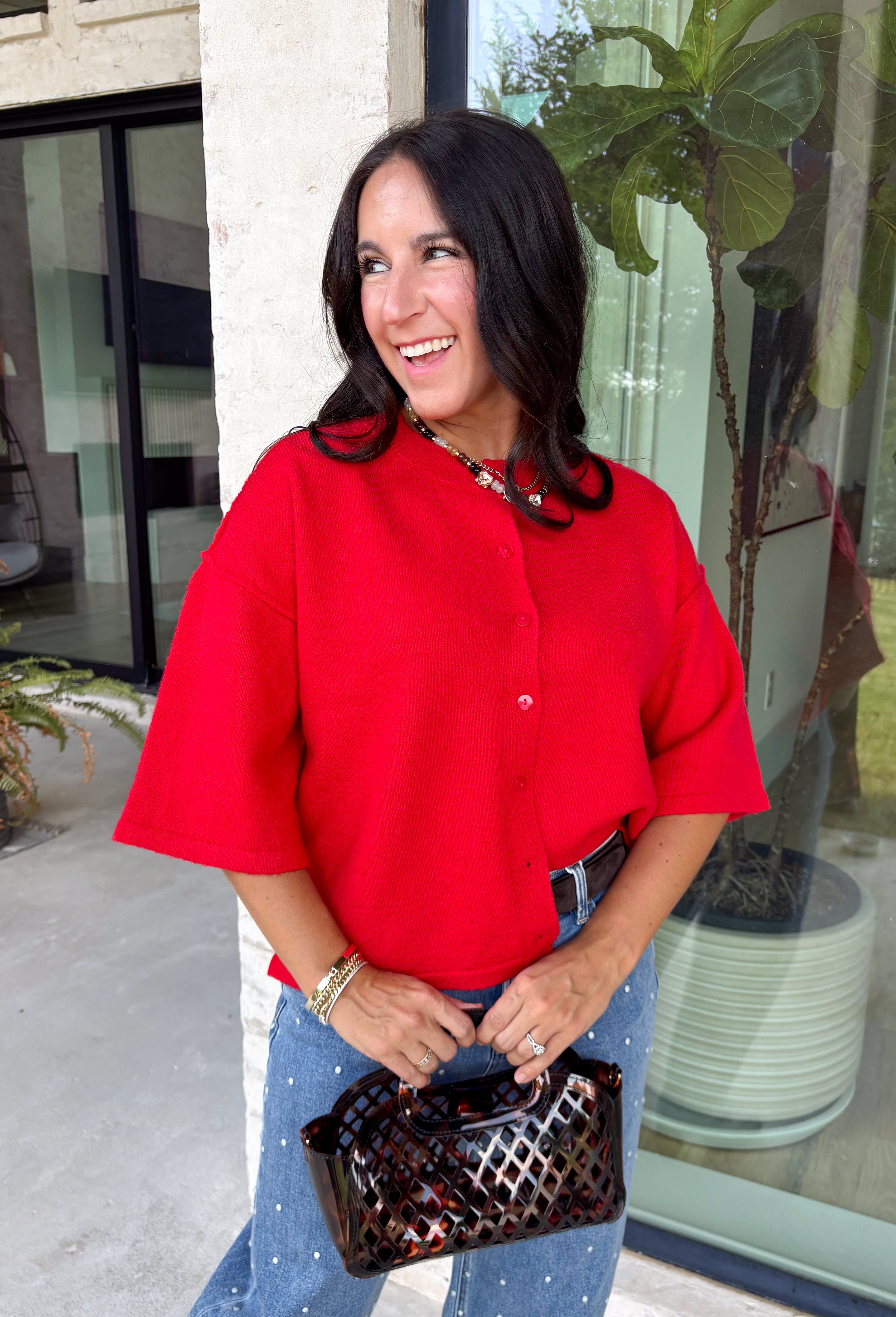 Add a timeless staple to your wardrobe with this cozy cardigan from Double Zero. Designed in a rich red hue, this short sleeve knit is the perfect combination of classic style and everyday comfort. The button-front design makes it easy to wear on its own as a sweater or layered over your favorite basics, while the ribbed neckline adds a polished finishing touch. Soft, versatile, and easy to style, this cardigan is one you'll find yourself reaching for all season long.