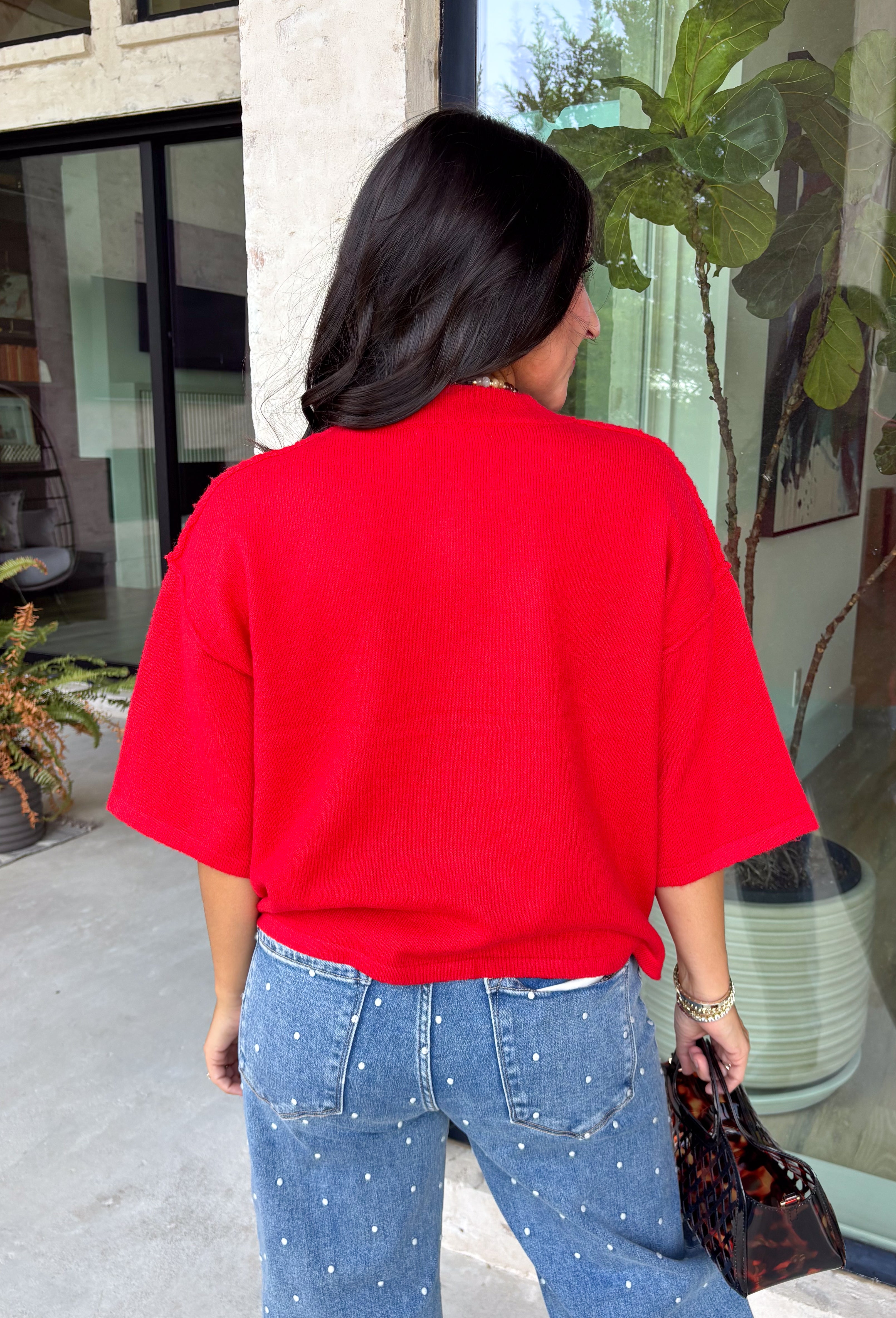 Add a timeless staple to your wardrobe with this cozy cardigan from Double Zero. Designed in a rich red hue, this short sleeve knit is the perfect combination of classic style and everyday comfort. The button-front design makes it easy to wear on its own as a sweater or layered over your favorite basics, while the ribbed neckline adds a polished finishing touch. Soft, versatile, and easy to style, this cardigan is one you'll find yourself reaching for all season long.