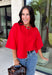 Add a timeless staple to your wardrobe with this cozy cardigan from Double Zero. Designed in a rich red hue, this short sleeve knit is the perfect combination of classic style and everyday comfort. The button-front design makes it easy to wear on its own as a sweater or layered over your favorite basics, while the ribbed neckline adds a polished finishing touch. Soft, versatile, and easy to style, this cardigan is one you'll find yourself reaching for all season long.