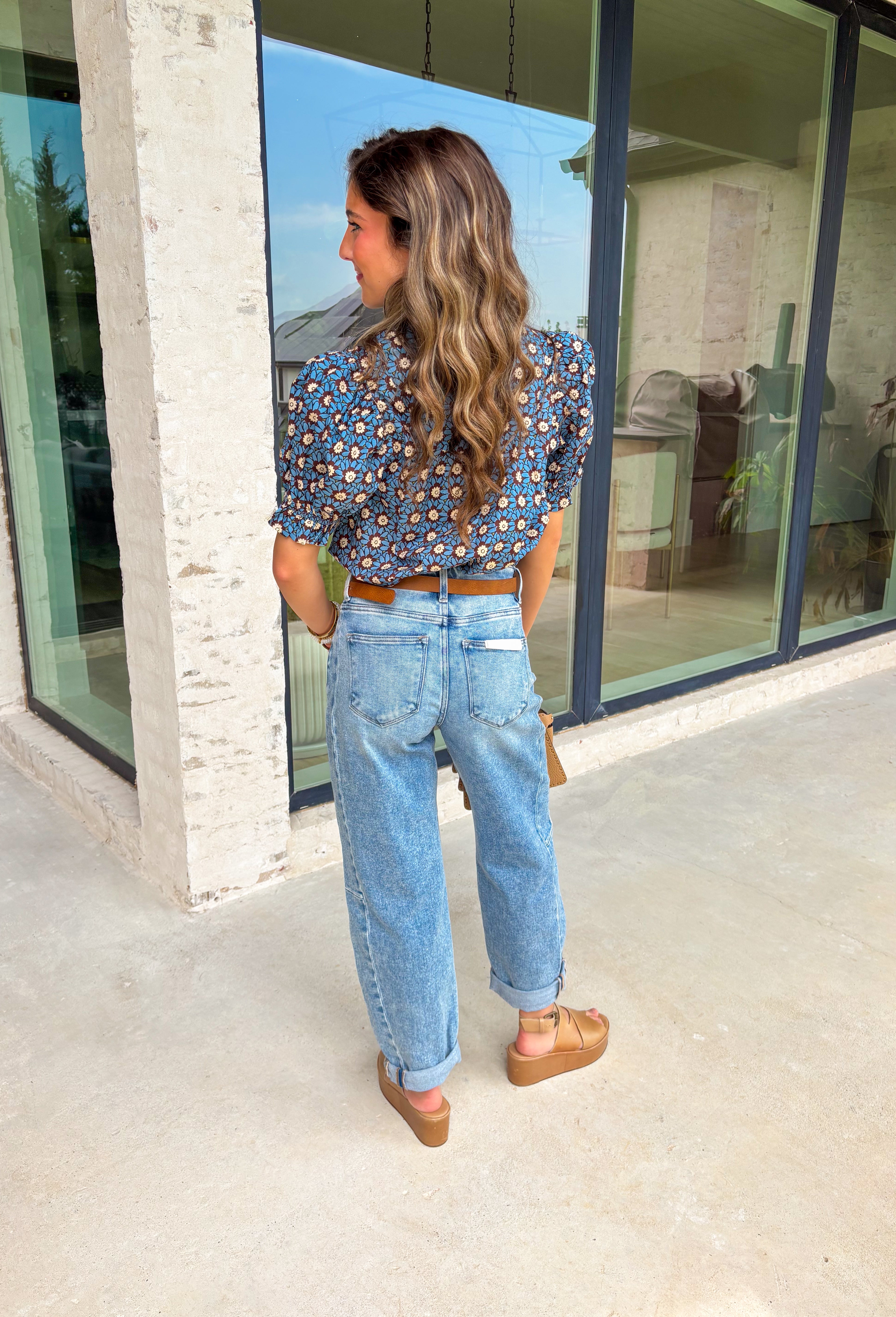 Fall florals have never looked so pretty! This ruffle edge puff sleeve top brings a cozy autumn vibe with its rich brown background and dreamy blue floral print. Whether you're heading to brunch or layering it under a jacket for a pumpkin patch moment, this one's an effortless favorite.